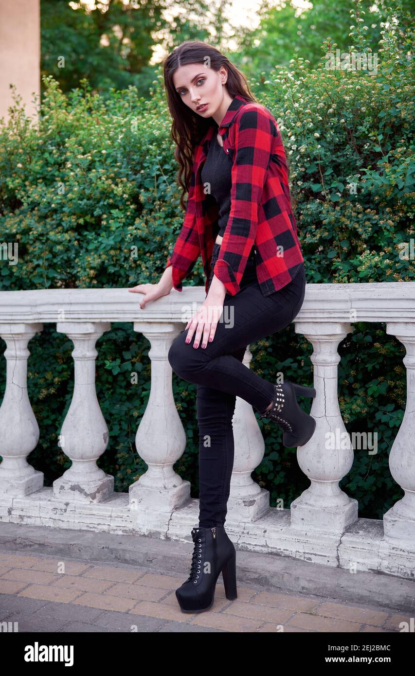niña con camisa de cuadros, jeans, zapatos en el parque Fotografía de stock - Alamy