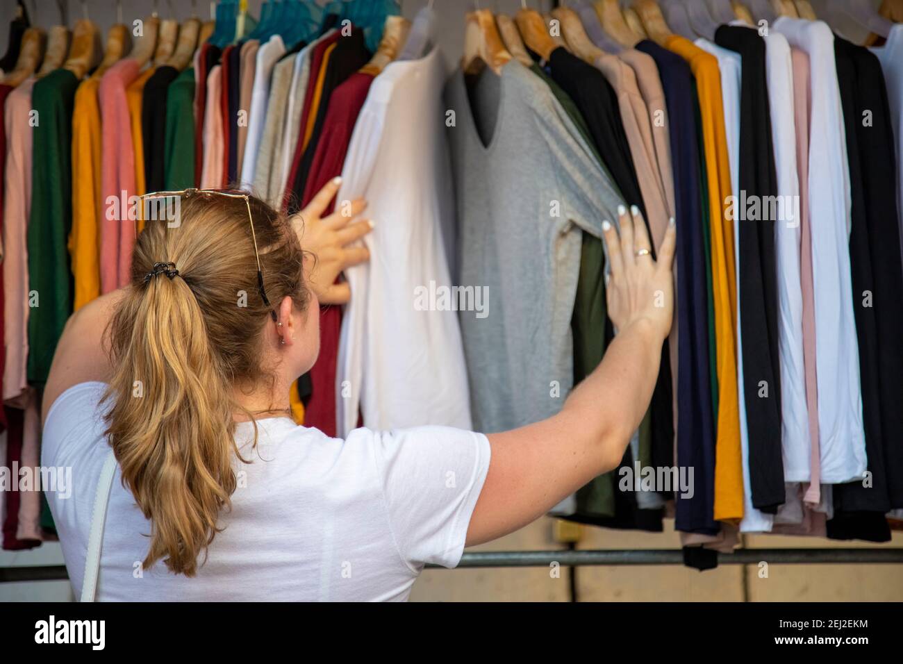la mujer elige la ropa que pasa por la cadena en la tienda en el mercado  Fotografía de stock - Alamy