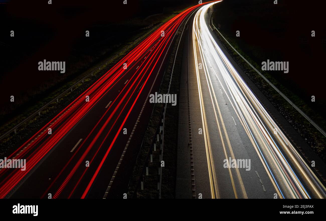Senderos de semáforo en una carretera por la noche Foto de stock