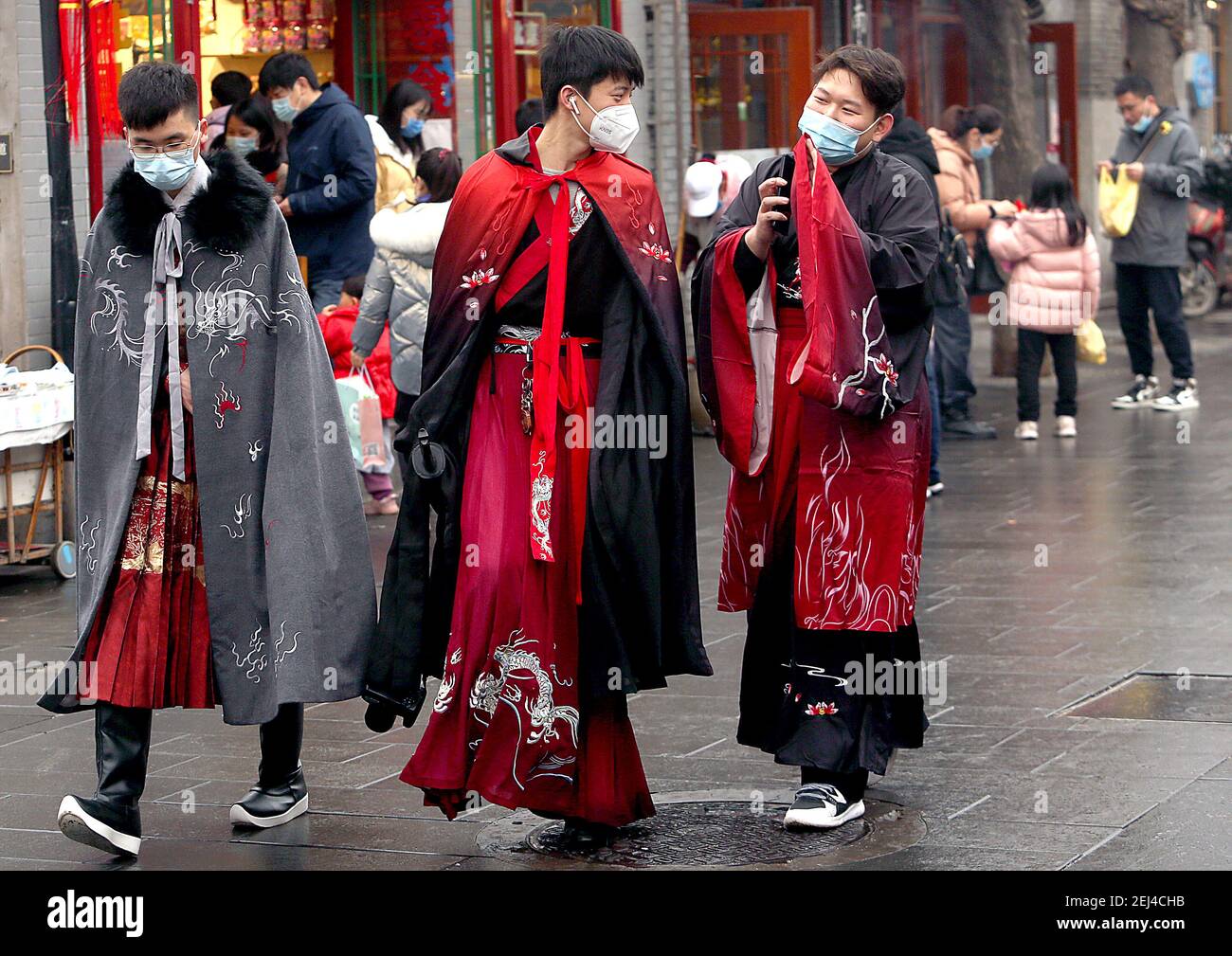 Pekín, China. 21 de febrero de 2021. Tres jóvenes chinos, vestidos con  trajes de guerrero, caminan por una zona comercial de moda en el centro de  Beijing el domingo, 21 de febrero