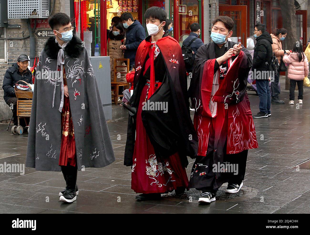 Pekín, China. 21 de febrero de 2021. Tres jóvenes chinos, vestidos con  trajes de guerrero, caminan por una zona comercial de moda en el centro de  Beijing el domingo, 21 de febrero