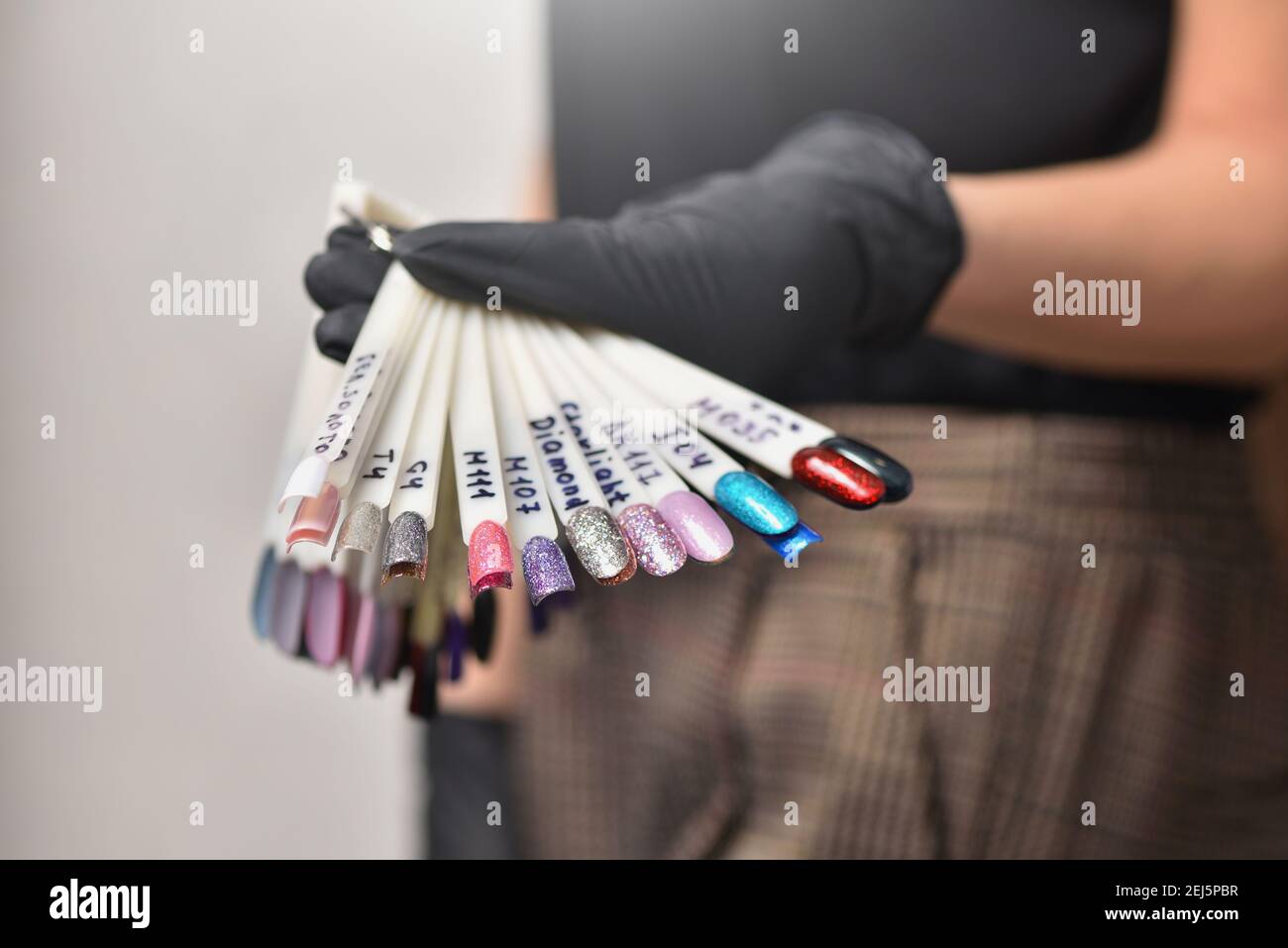 Manicurista que demuestra las opciones de color de esmalte de uñas Foto de stock