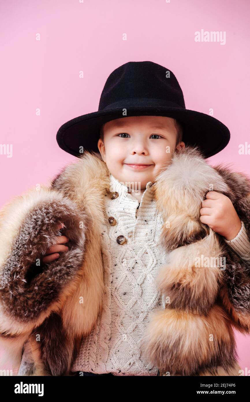 Adorable niño posando un abrigo de de gran tamaño y.. sombrero clásico Fotografía de stock - Alamy