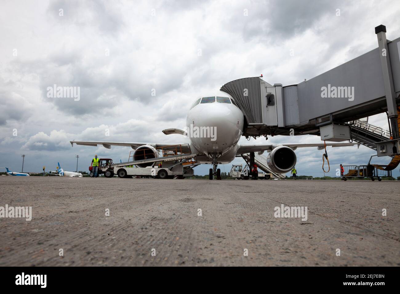 Embarque de pasajeros en el avión a través del puente de embarque. El avión aterriza en el aeropuerto internacional. Cargando equipaje. Avión blanco. Terminal Foto de stock