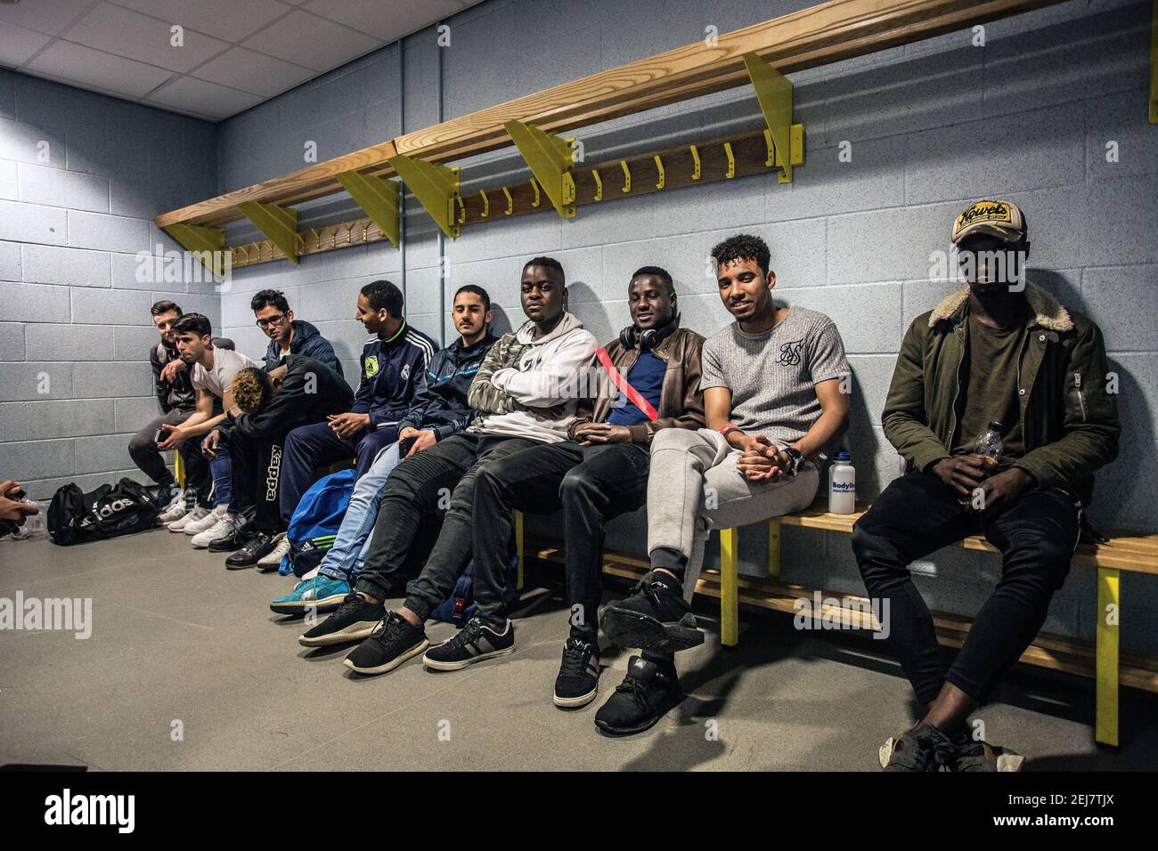 Jugadores refugiados sentados en el vestidor en el Campo de Entrenamiento, Wetherby, Reino Unido, Integración Social de Refugiados. Foto de stock