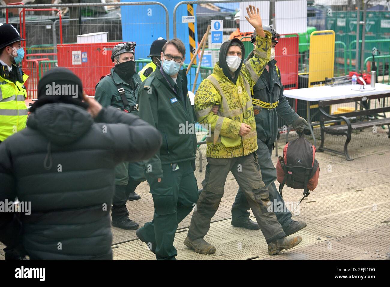 Un activista anti-HS2, conocido como 'Larch', camina con paramédicos cuando sale de Euston Square Gardens, Londres, después de que fue retirado por los bailaíffs de un túnel de 100 pies donde había estado protestando. Fecha del cuadro: Lunes 22 de febrero de 2021. Foto de stock