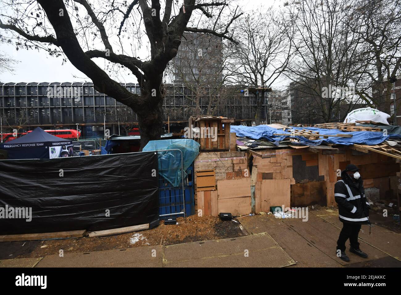 Un guardia de seguridad está al lado de lo que queda del campamento anti-HS2 en Euston Square Gardens, Londres. Fecha del cuadro: Lunes 22 de febrero de 2021. Foto de stock