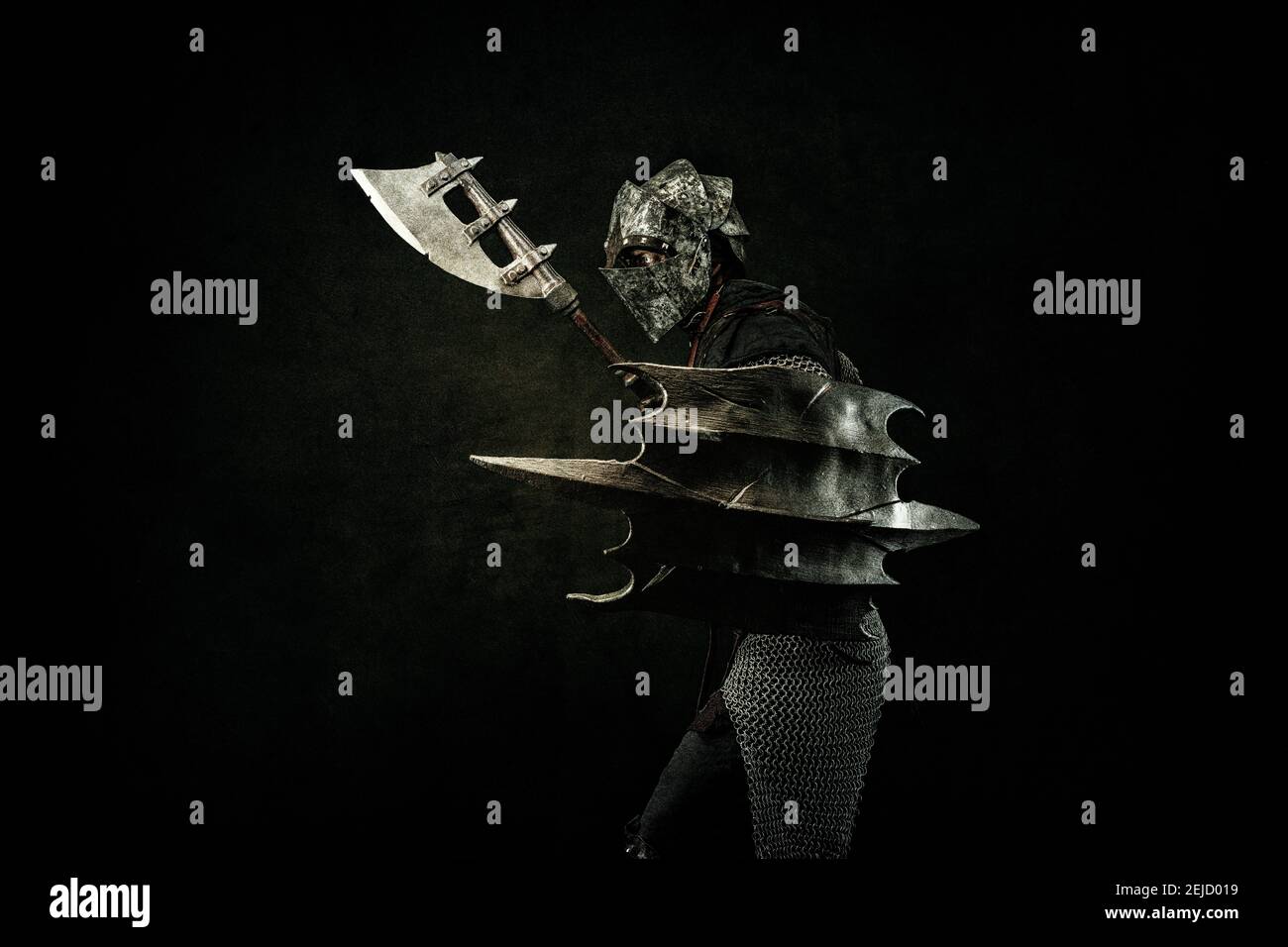 Luchador medieval en armadura, de perfil, llevando un escudo y un hacha