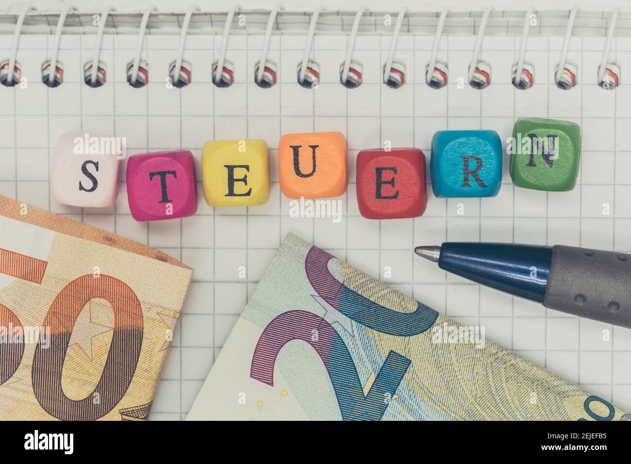 Concepto Steuern (en impuestos alemanes) con cubos de letras y billetes de banco. Foto de stock
