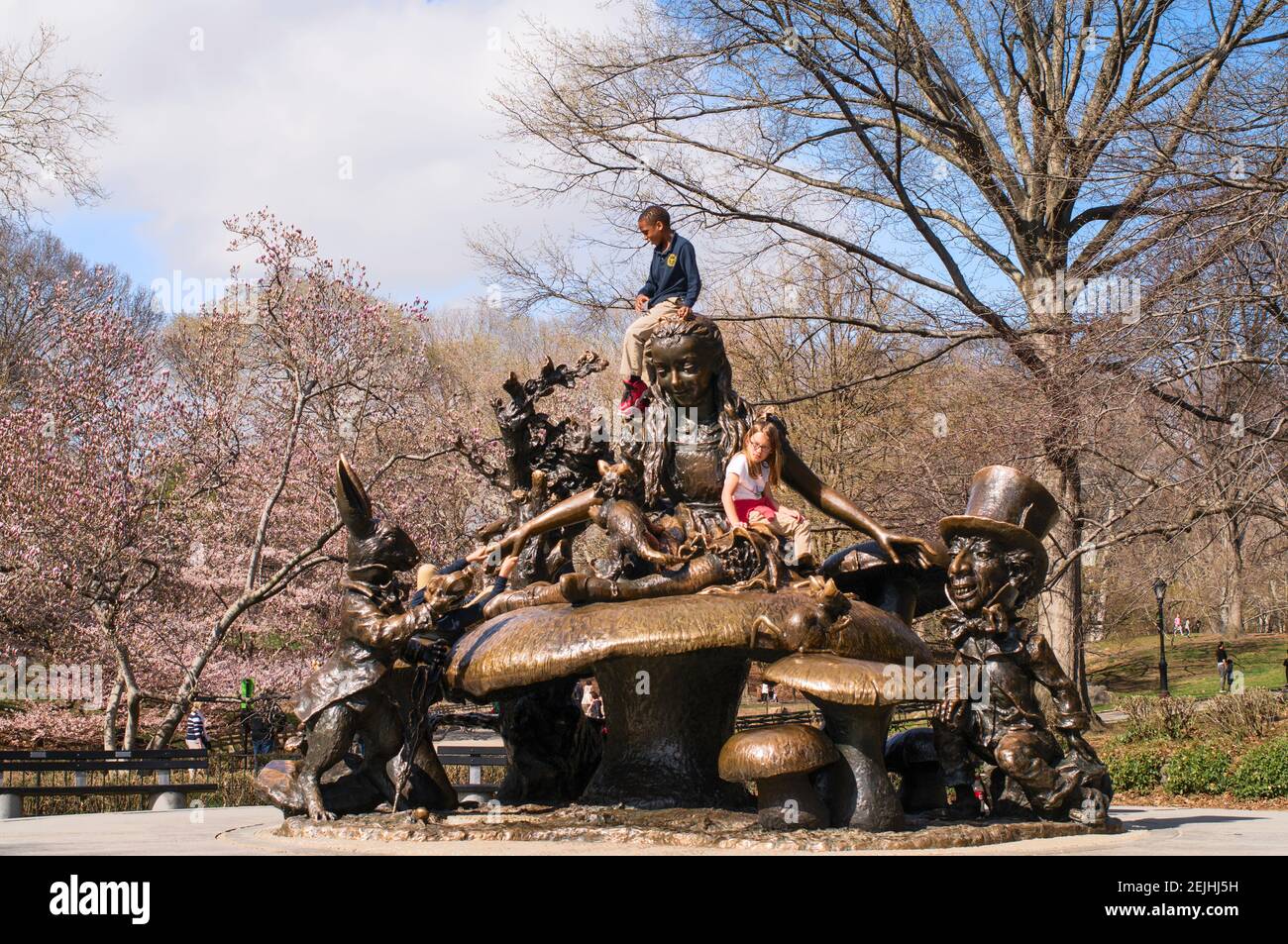 Niños jugando en la escultura de bronce Alice in Wonderland de José de Creeft en Central Park, Nueva York, Nueva York, Estados Unidos Foto de stock