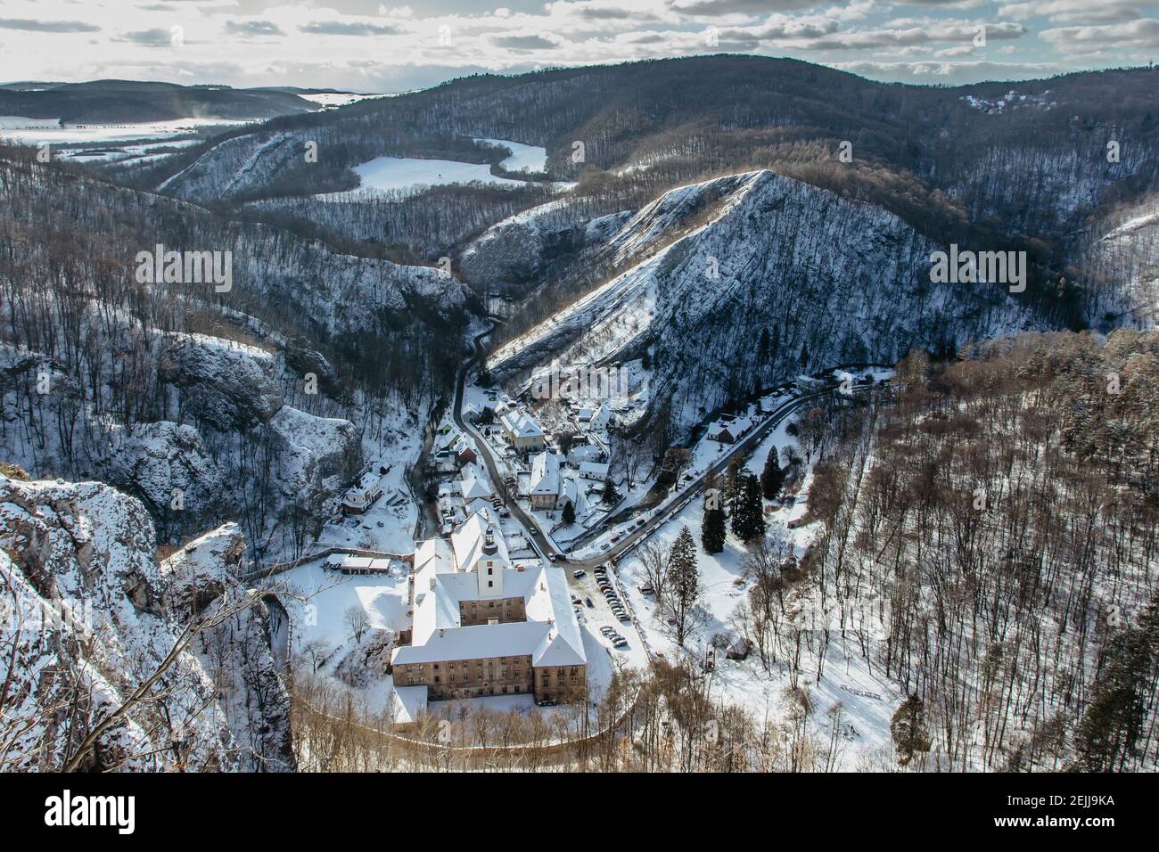 Vista aérea de invierno de Svaty Jan pod Skalou, pequeño pueblo pintoresco en Bohemia Central, República Checa. Monasterio escondido bajo acantilados y rocas en Foto de stock