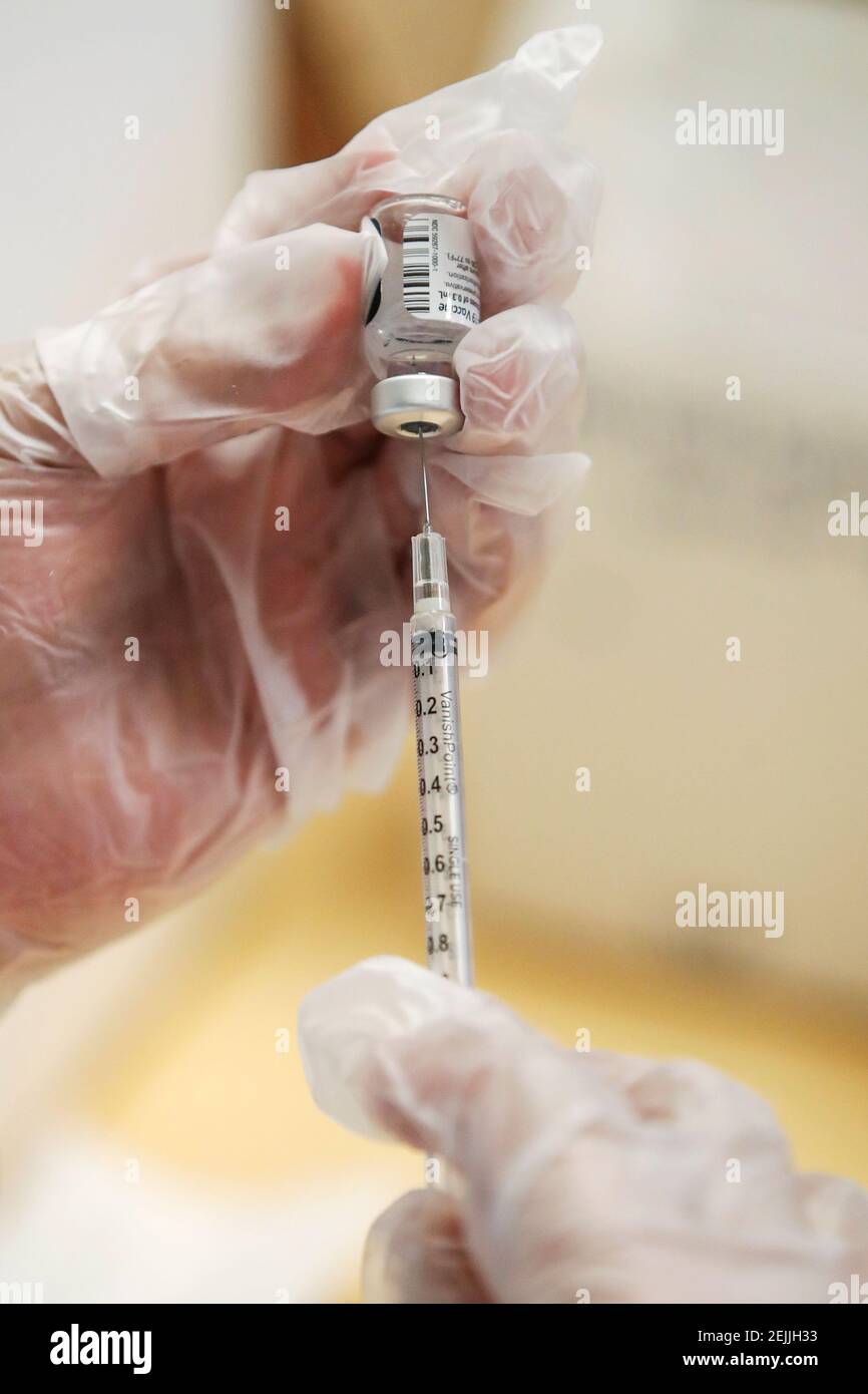 El profesional de salud de Walgreens Luis S. Solano prepara una dosis de la vacuna Pfizer-BioNTec contra la enfermedad del coronavirus (COVID-19) en los apartamentos Victor Walchirk en Evanston, Illinois, EE.UU. 22 de febrero de 2021. REUTERS/Kamil Krzaczynski Foto de stock