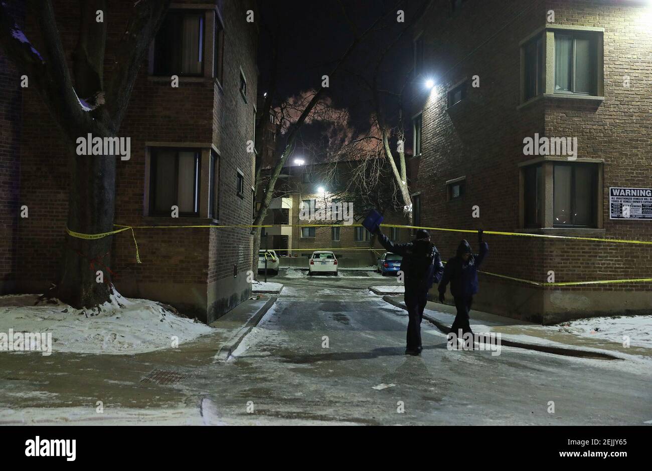 Los oficiales cruzan la cinta de escena del crimen en el complejo de viviendas de Parkway Gardens, donde al menos seis personas fueron fusiladas en un apartamento el 14 de febrero de 2020, en Chicago. (Foto de John J. Kim/Chicago Tribune/TNS/Sipa USA) Foto de stock
