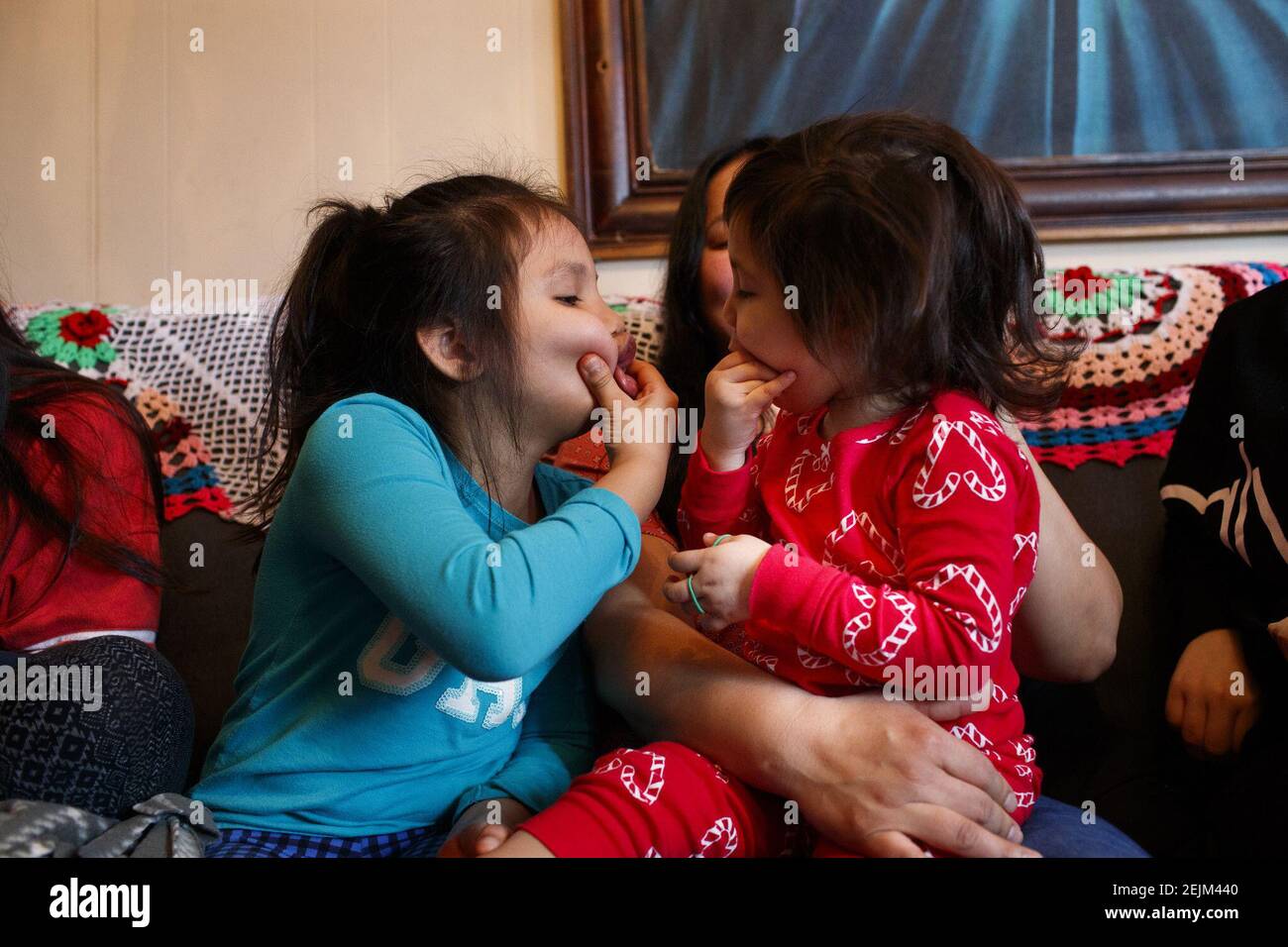 Evelyn Cisneros, de 7 años de edad, juega con su hermana Nicole de 2 años mientras está sentada en el regazo de su madre. (Armando L. Sanchez / Chicago Tribune/TNS) Foto de stock