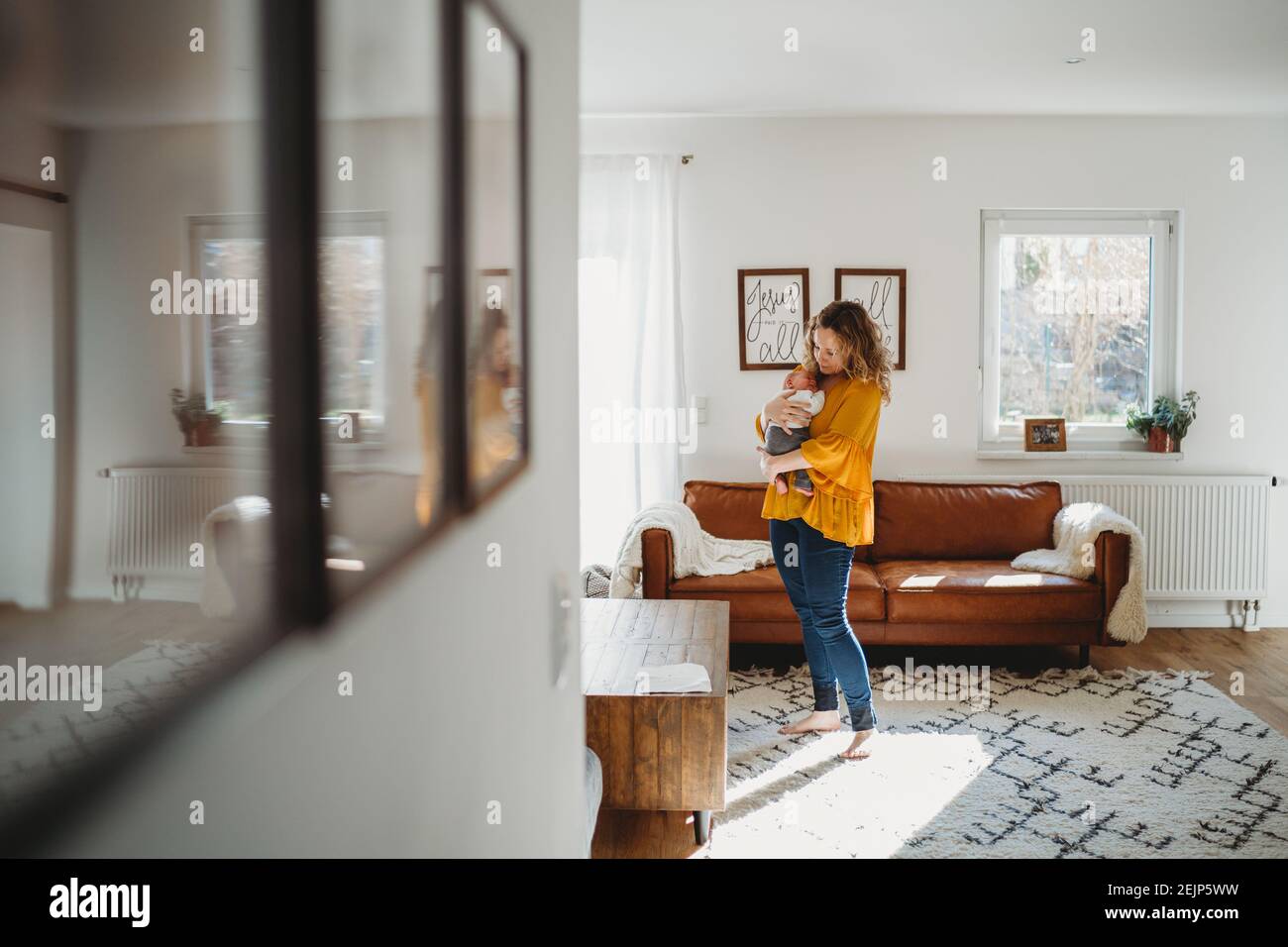 Mamá sostiene al bebé de pie en la sala de estar con reflexión imágenes  Fotografía de stock - Alamy