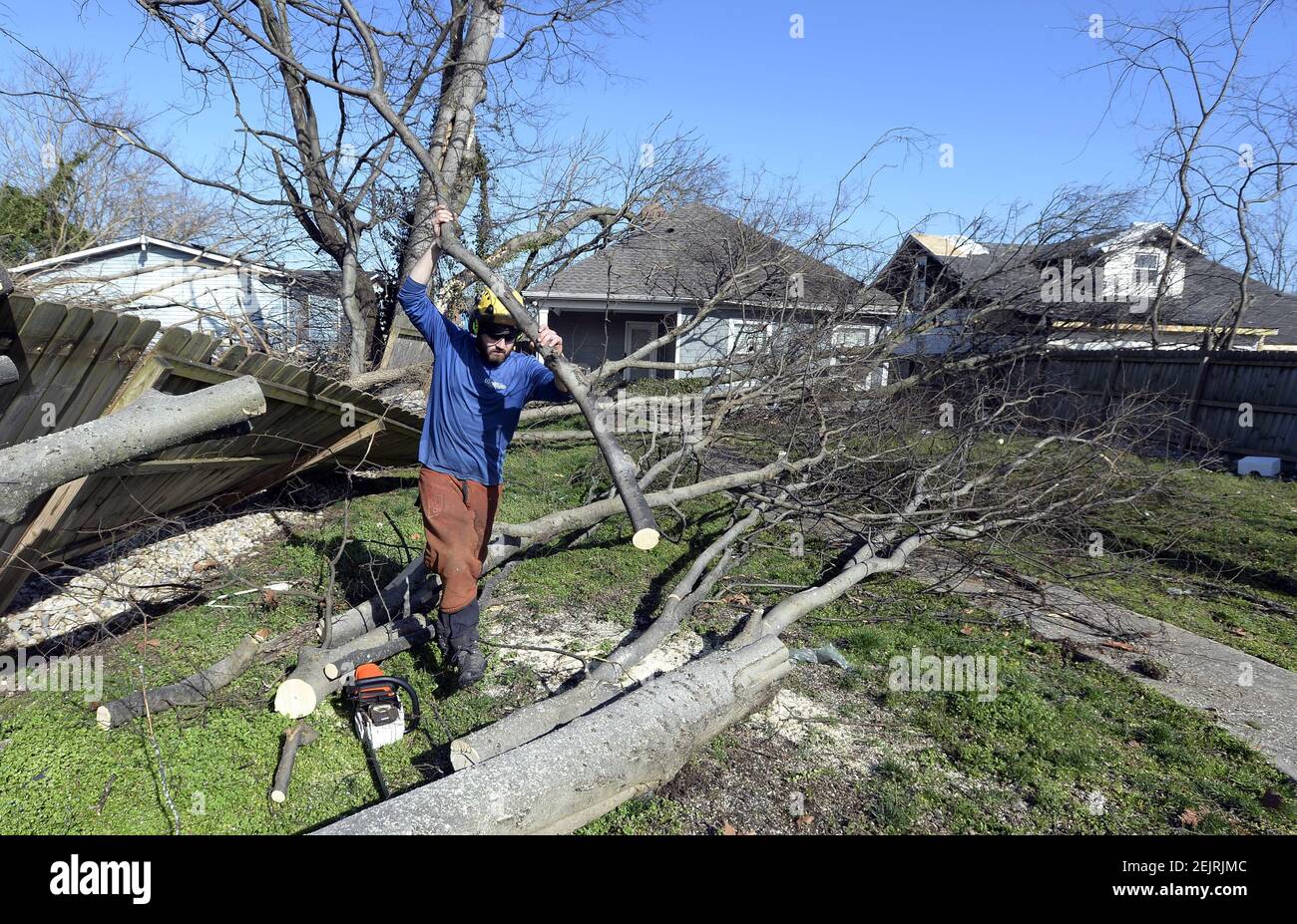 3 de marzo de 2020; Nashville, TN, EE.UU.; Un miembro de la banda de sonido limpia los desechos de tornados de un patio a lo largo de la 16th Avenue North el miércoles, 4 de marzo de 2020, en el norte de Nashville, Tennessee. Crédito obligatorio: Mark Zaleski/The Tennessean a través de la RED USA TODAY/Sipa USA Foto de stock