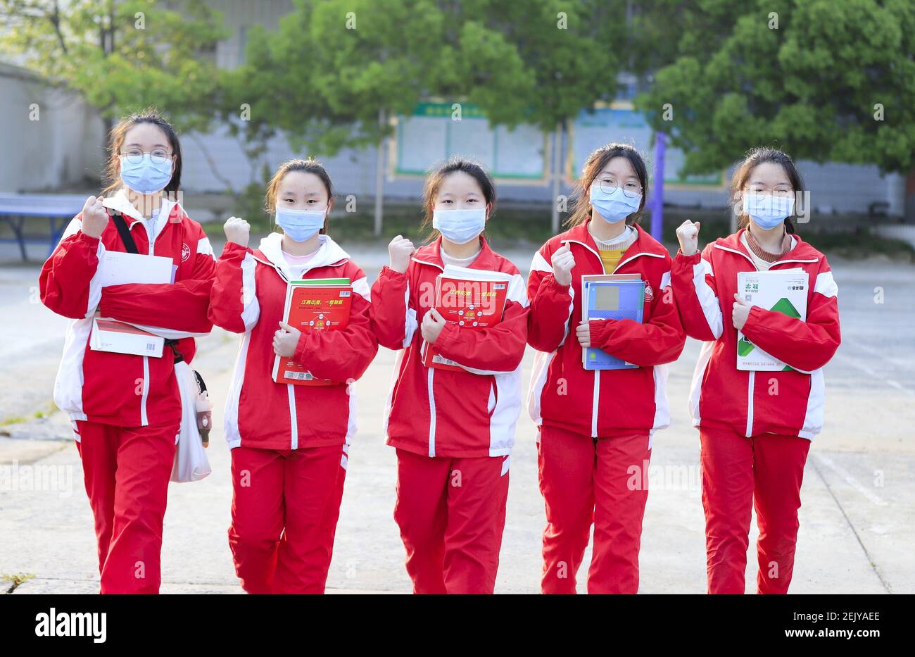 Los estudiantes con máscara hacer en el patio de juegos después de dos y medio vacaciones de invierno en escuela intermedia local, condado Hukou, ciudad de Jiujiang, provincia
