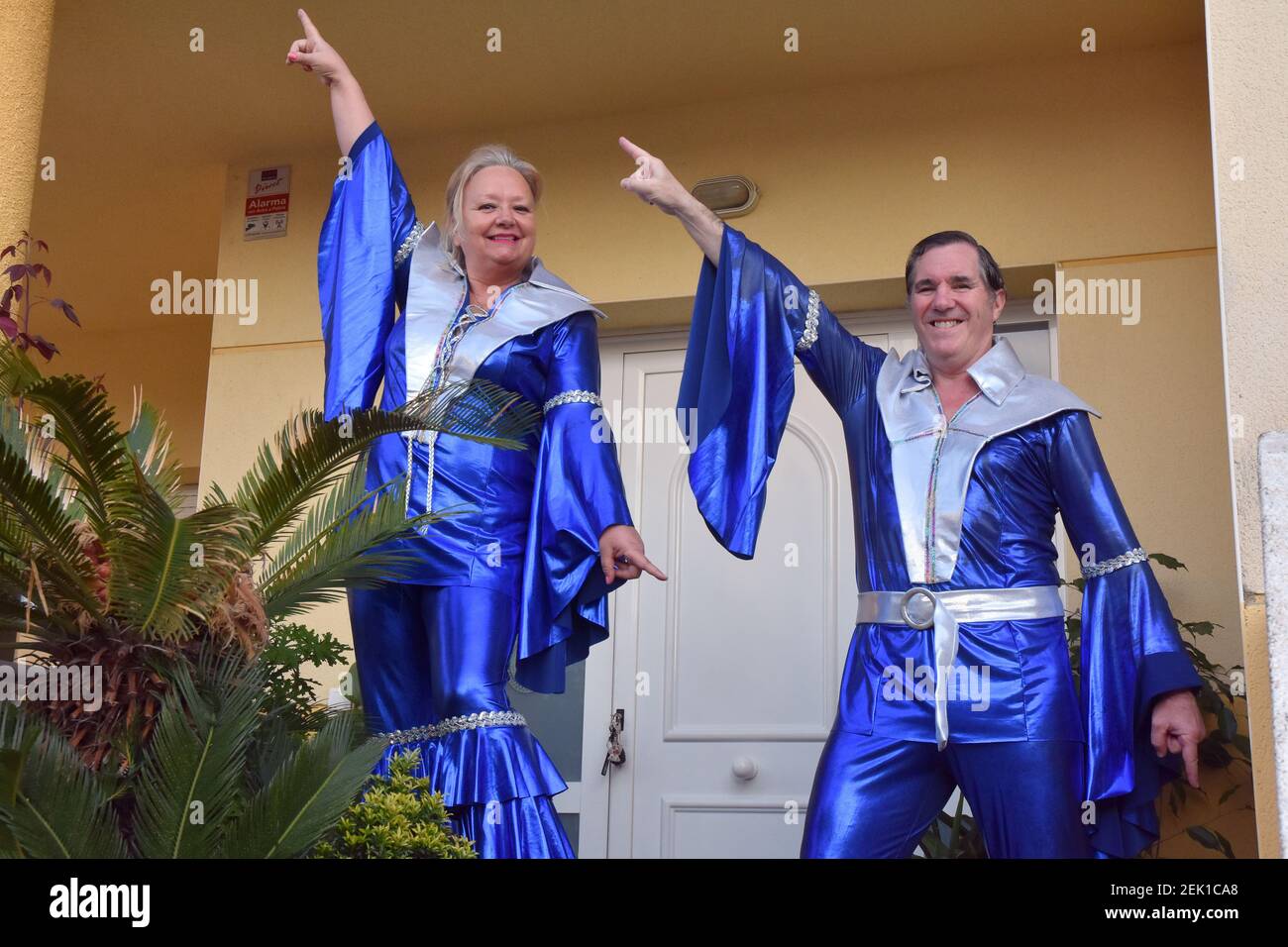Una pareja disfrazada de cantantes del grupo ABBA durante la actuación de  música de los años 80 para entretener a sus vecinos durante el  confinamiento. Los residentes del barrio Mas d'en Gual