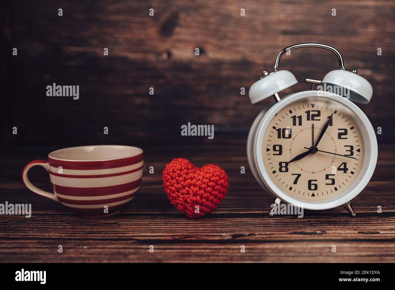 Reloj despertador, forma de corazón y café en la mesa de madera Fotografía  de stock - Alamy