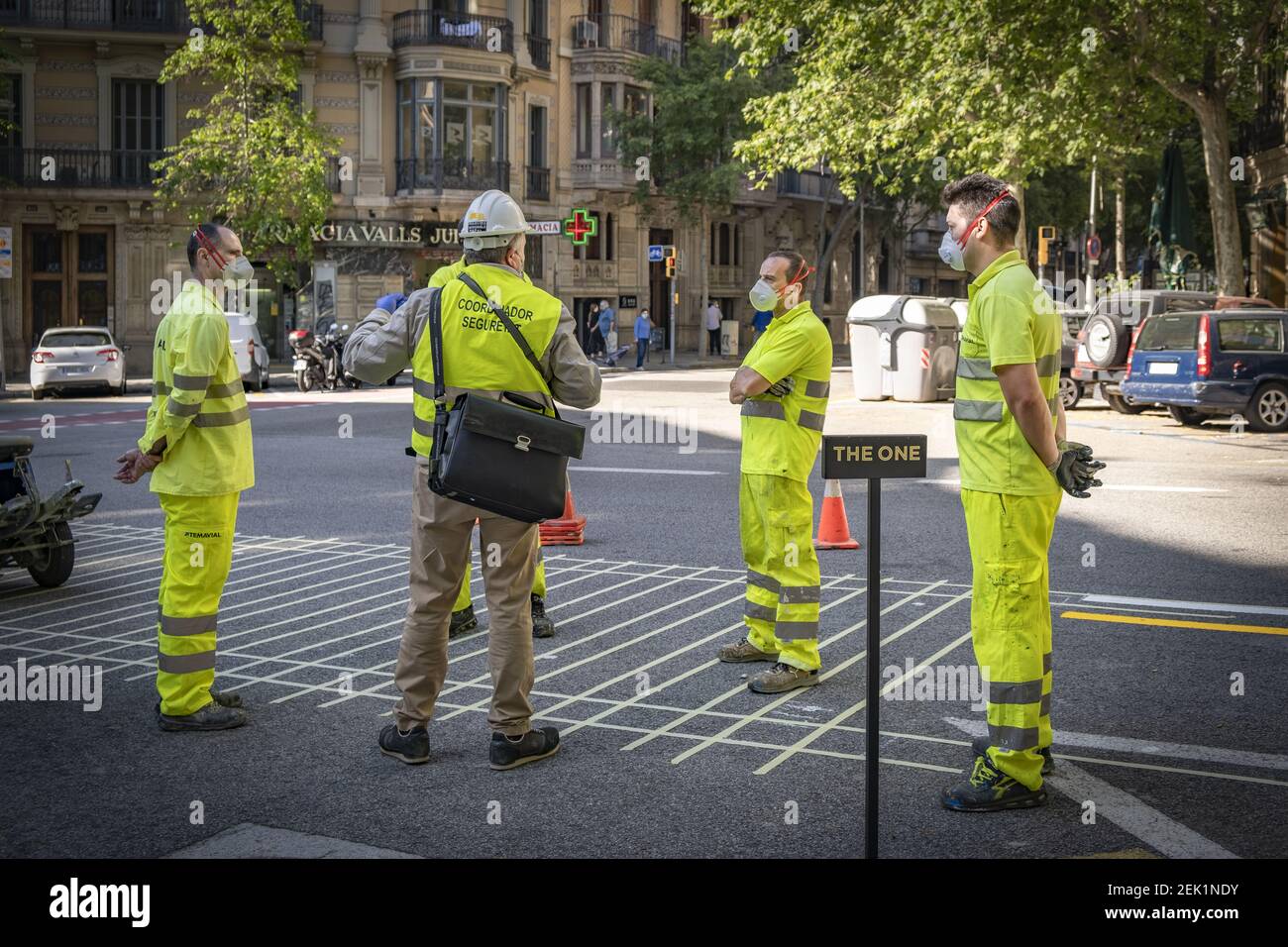 Se ve al coordinador de seguridad de una brigada de pintores dando  instrucciones a los trabajadores para que señalen un nuevo carril bici en  una carretera durante la crisis del coronavirus. El