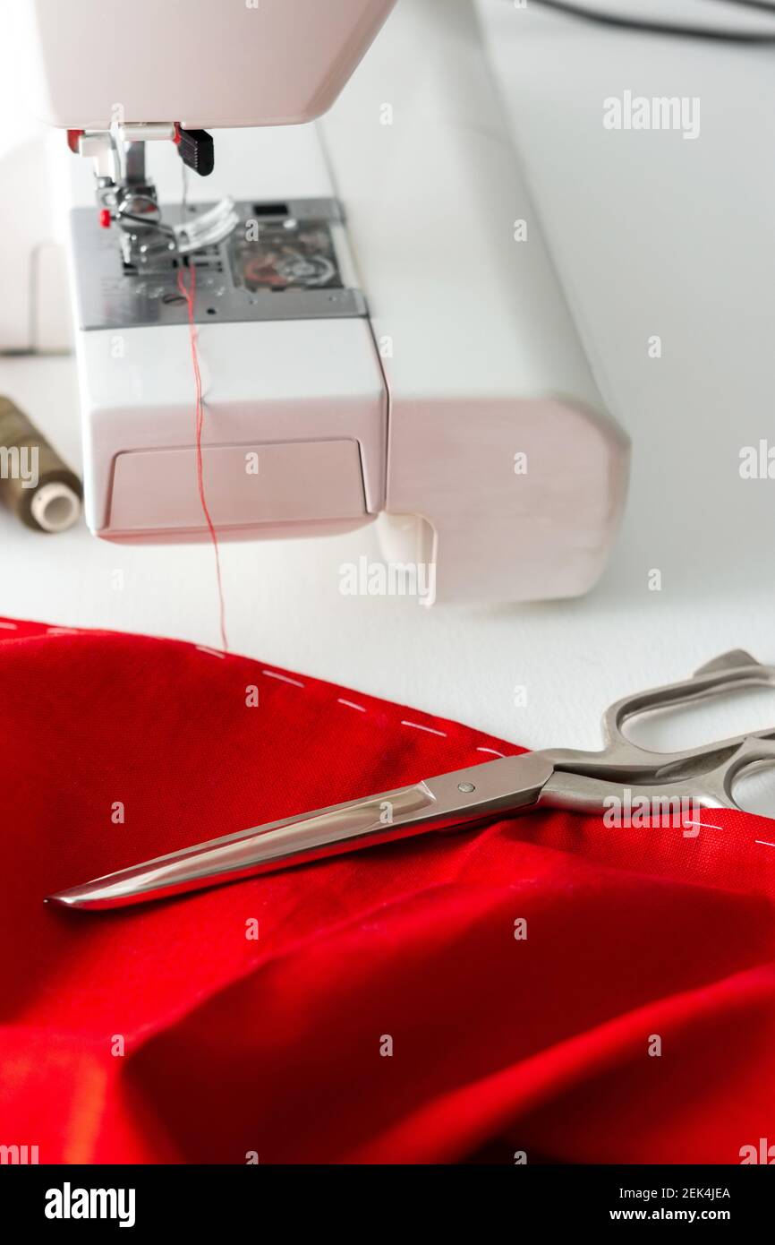Máquina de coser moderna con tela roja y gris, hilo y tijeras, corte y  costura en casa, ocio en casa y hobby Fotografía de stock - Alamy