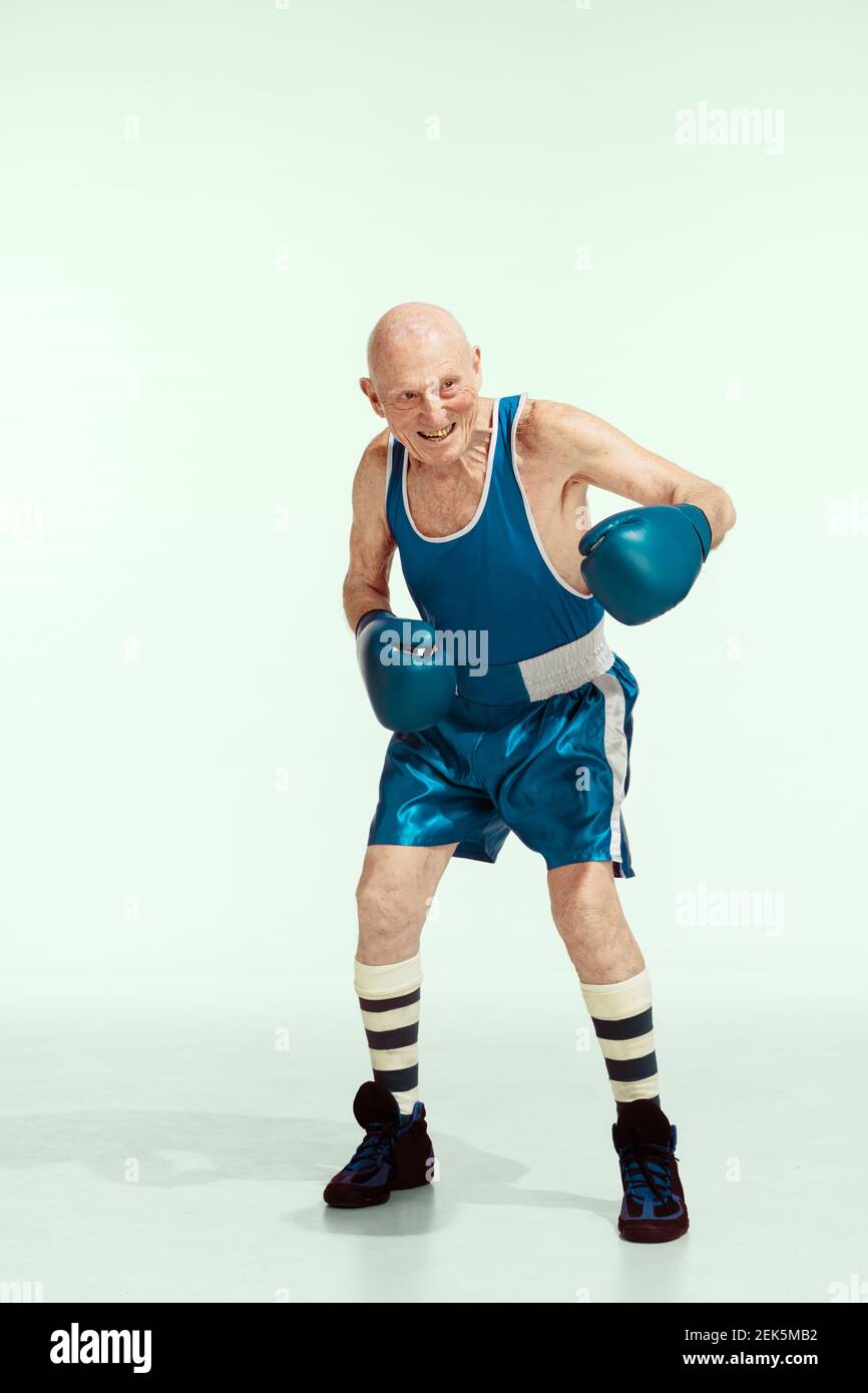 Coincidencia. Hombre mayor vestido de ropa deportiva sobre fondo de estudio. El modelo masculino caucásico en gran permanece activo y deportivo. Concepto de deporte, actividad, movimiento, bienestar. CopySpace, anuncio Fotografía