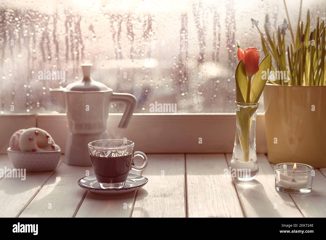 Café oriental en la tradicional cafetera turca de cobre con flores en el alféizar de la ventana. Alféizar de madera con tulipanes de naranja y maceta de flores de jacinto Foto de stock
