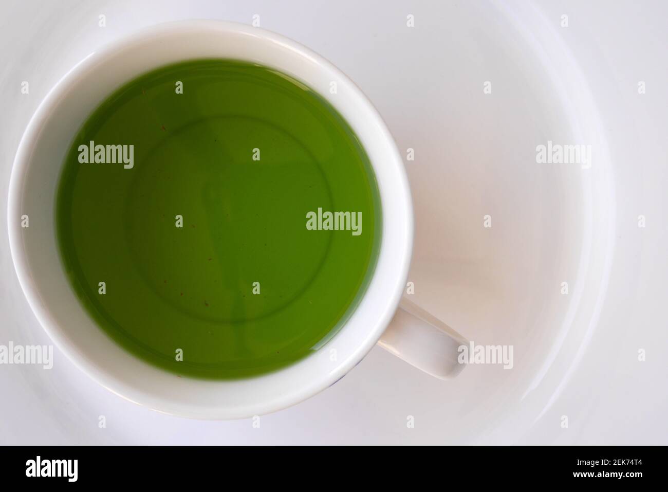 Una mezcla de la flor de la arveja de la mariposa orgánica y té del azafrabajo en una taza blanca Foto de stock