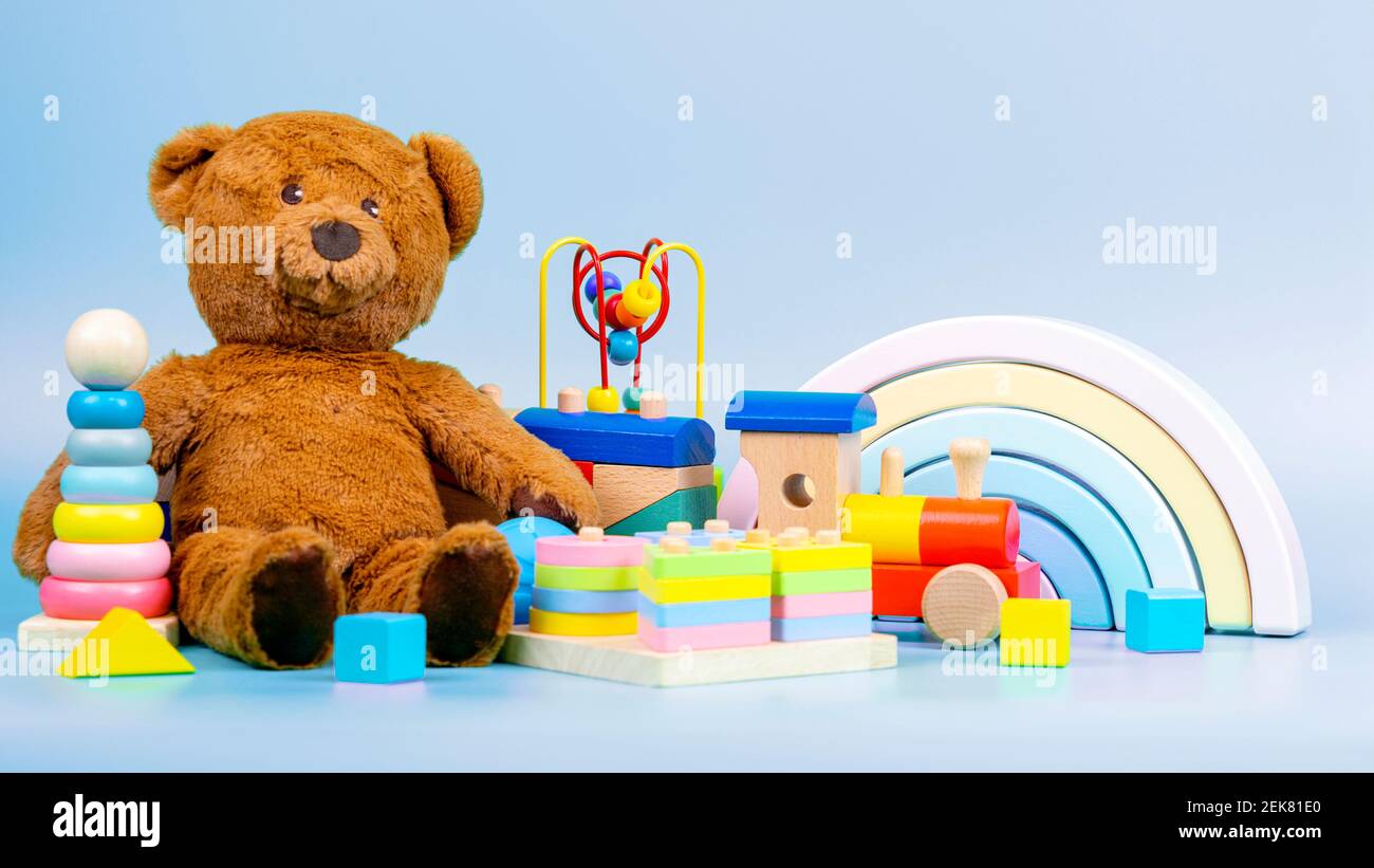 Colección de juguetes para niños. Oso de peluche, arco iris de madera, tren y  juguetes de bebé sobre fondo azul claro Fotografía de stock - Alamy