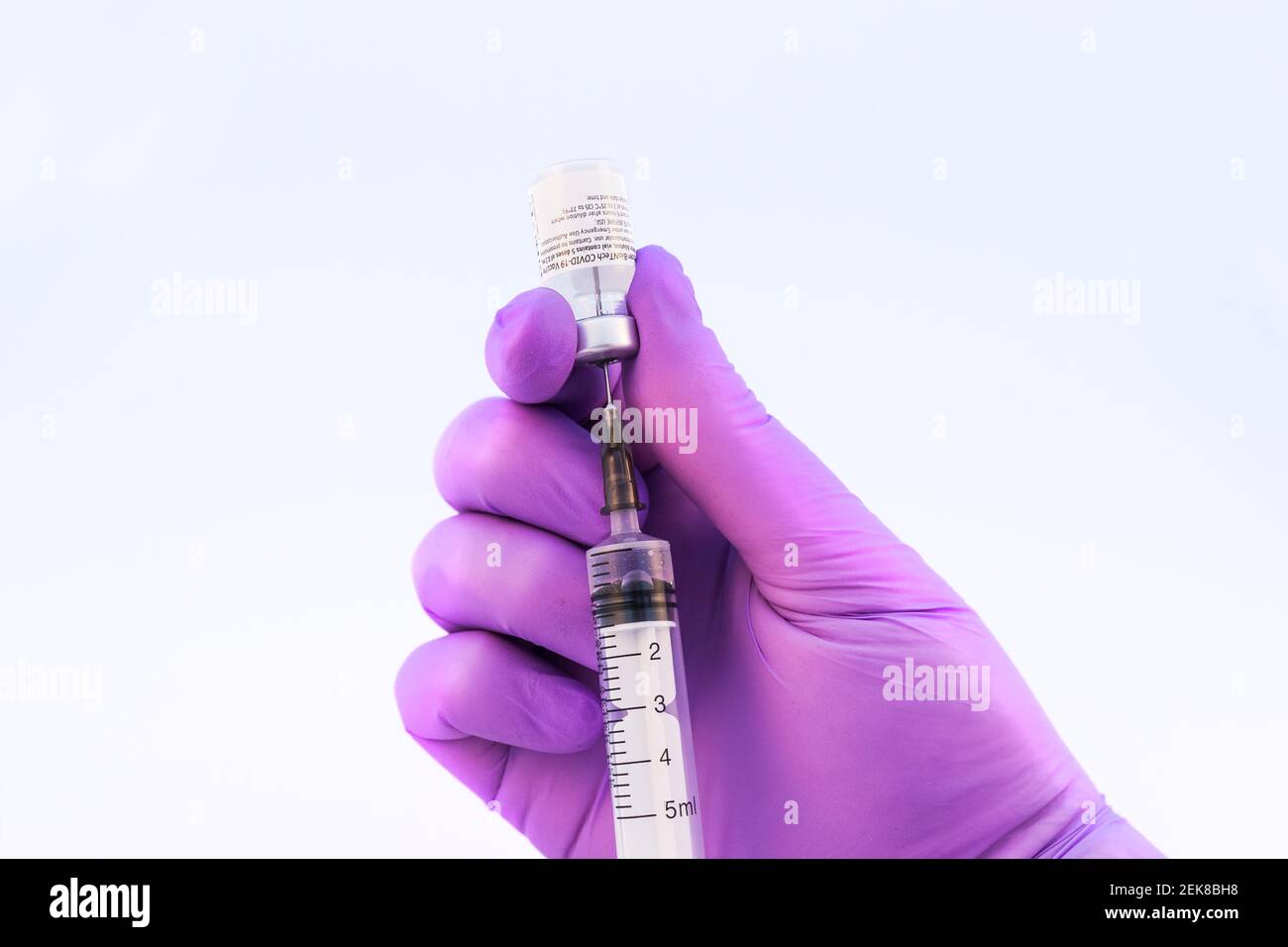 Brasov, Rumania - 21 de febrero de 2021: Médico que usa la vacuna Pfizer-BioNTech Covid-19 sobre fondo blanco. Foto de stock