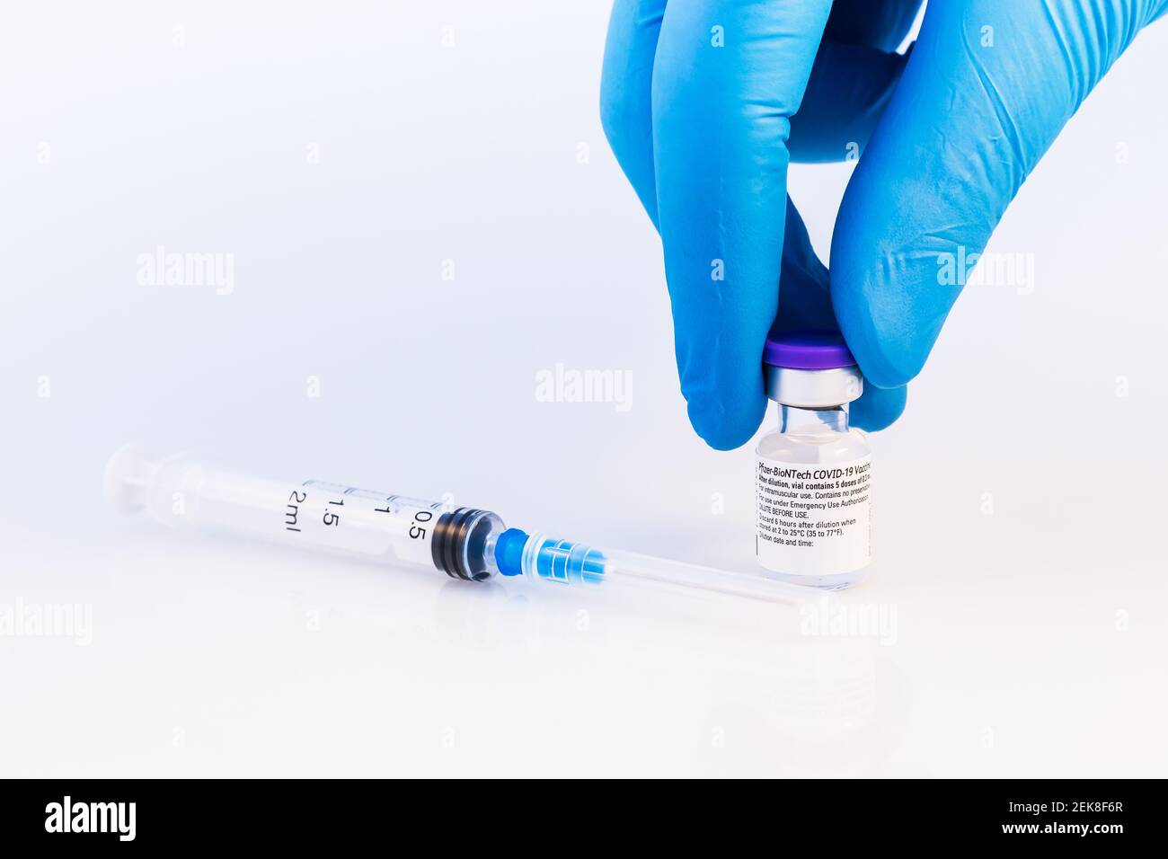 Brasov, Rumania - 21 de febrero de 2021: Médico o científico que sostiene la vacuna Pfizer-BioNTech Covid-19 sobre fondo blanco. Foto de stock
