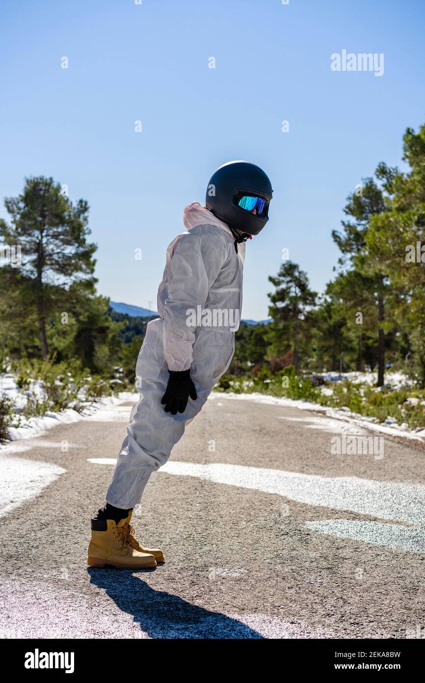Hombre con ropa de esquí y gafas jugando mientras está de pie en la carretera Foto de stock