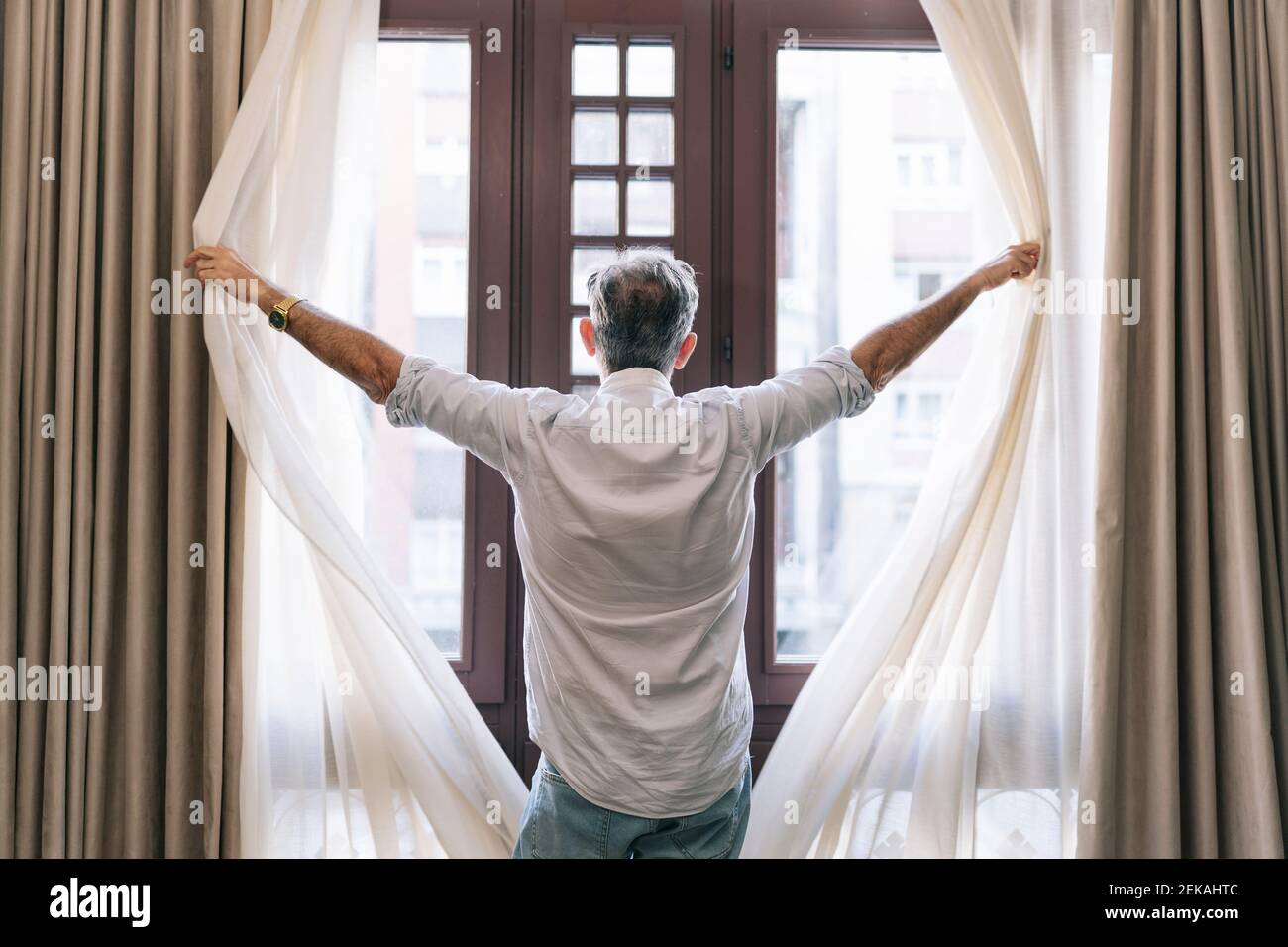 El hombre abrir las cortinas en la habitación del hotel Fotografía de stock  - Alamy