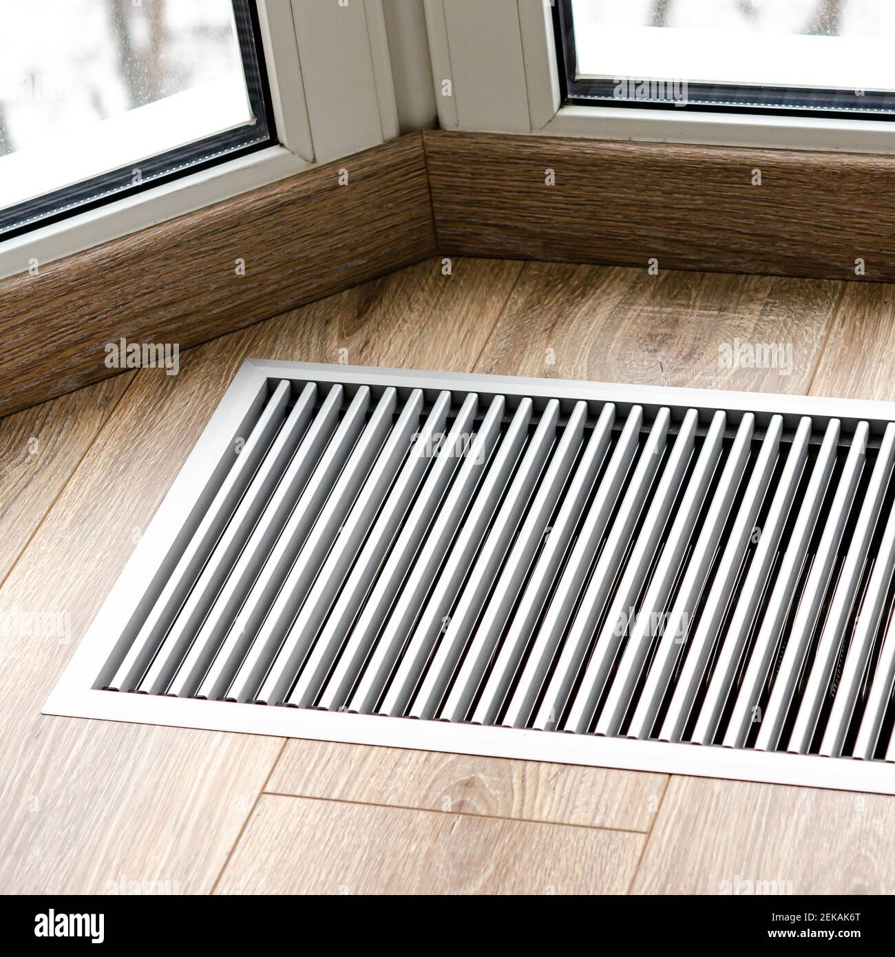 Rejilla protectora del radiador integrada en el suelo para calentar ventanas  panorámicas. Rejilla de calefacción con ventilación por el suelo en suelos  de madera Fotografía de stock - Alamy