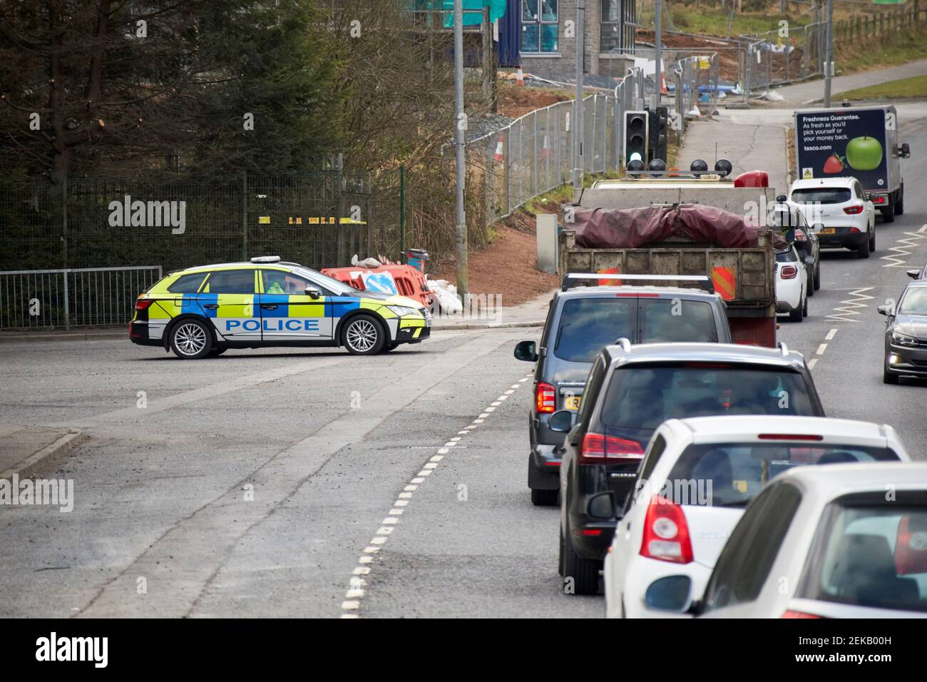 cola de coches esperando en el puesto de control de la policía del psni durante el coronavirus Restricciones de viaje Newtownabbay Irlanda del Norte Reino Unido Foto de stock