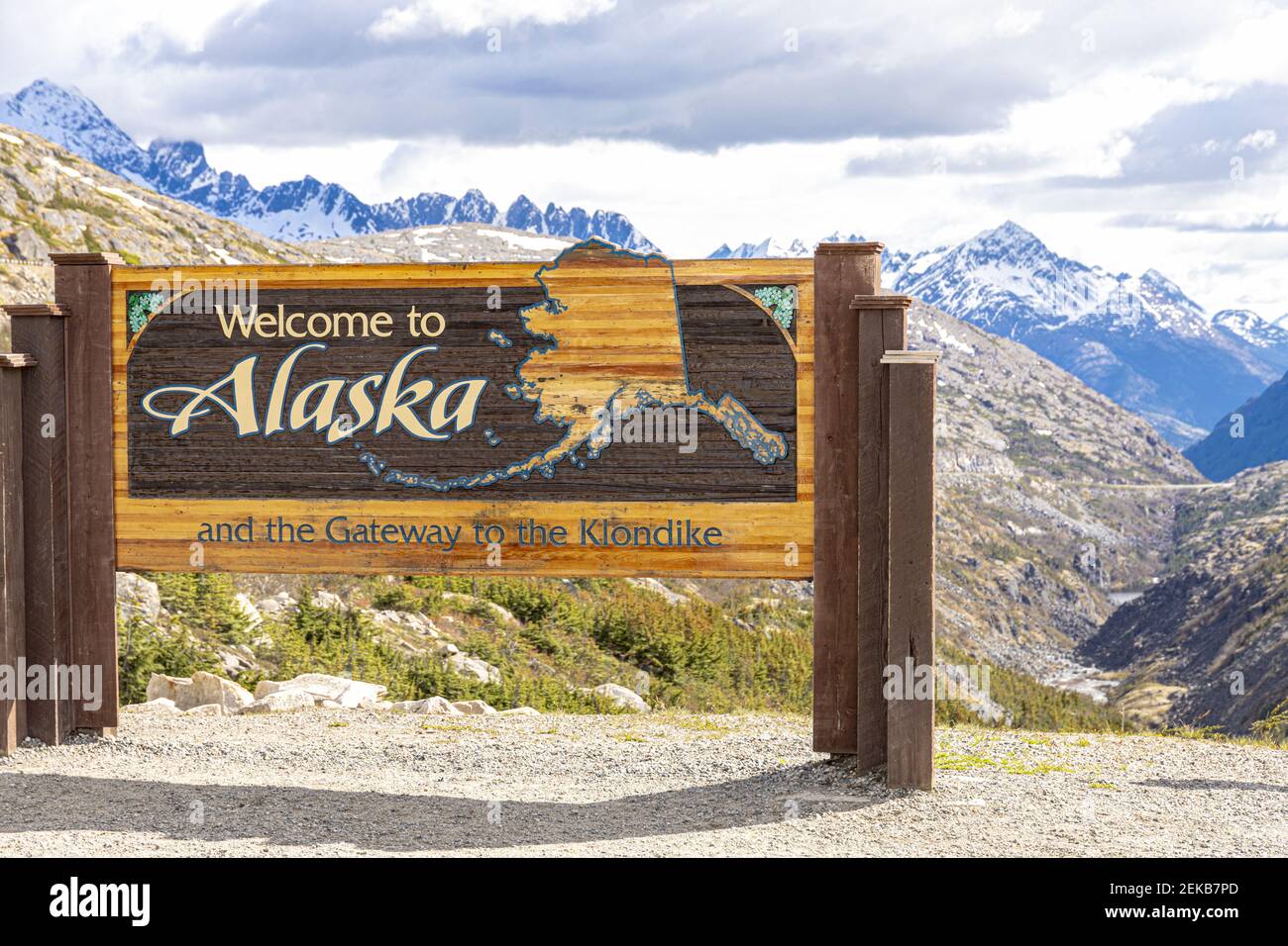 Bienvenido a Alaska signo a principios de junio en la frontera de Canadá / EE.UU. Junto a la autopista Klondike NE de Skagway, Alaska, EE.UU Foto de stock