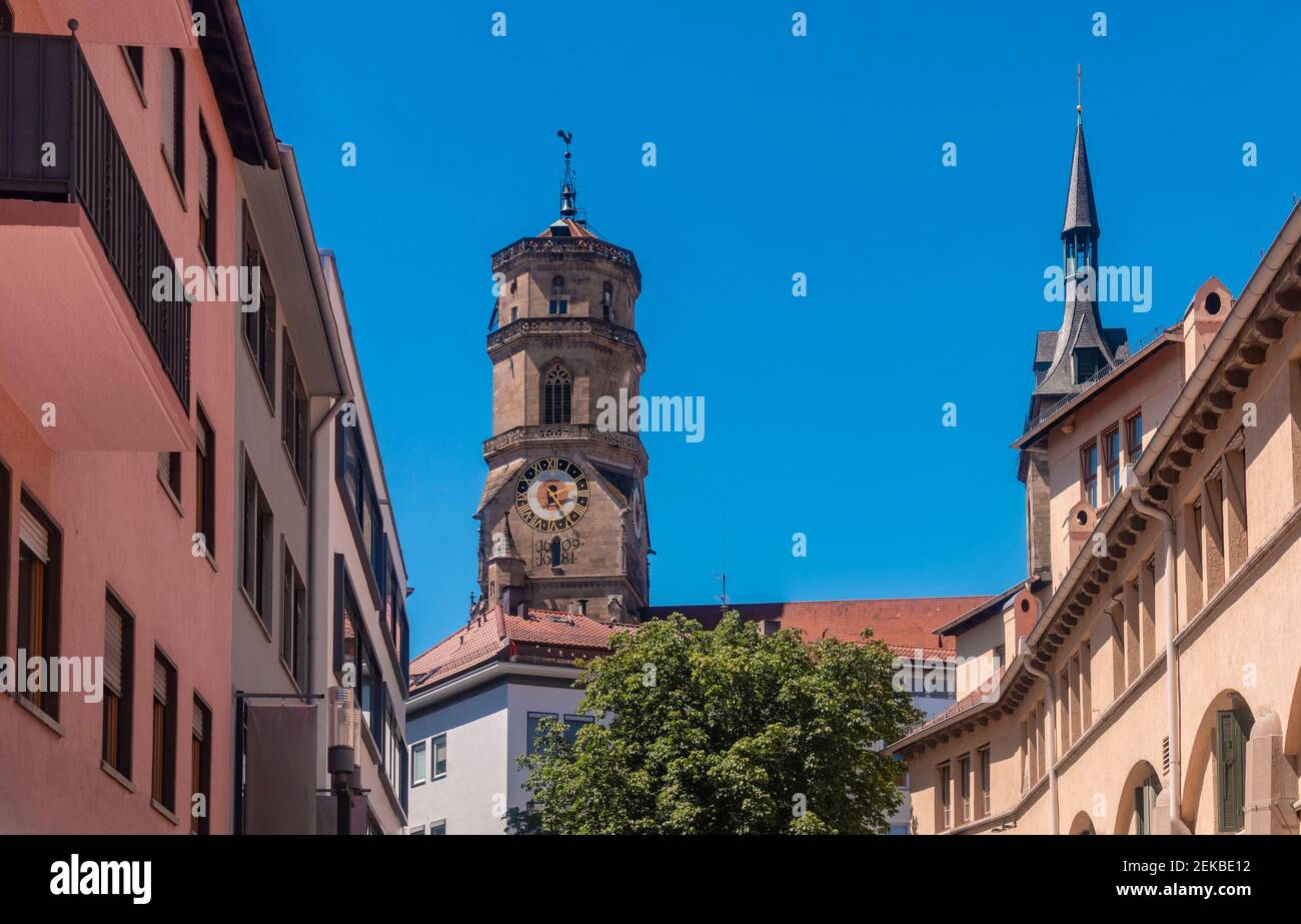 Alemania, Baden-Wurttemberg, Stuttgart, campanario de la iglesia Stiftskirche con casas en primer plano Foto de stock
