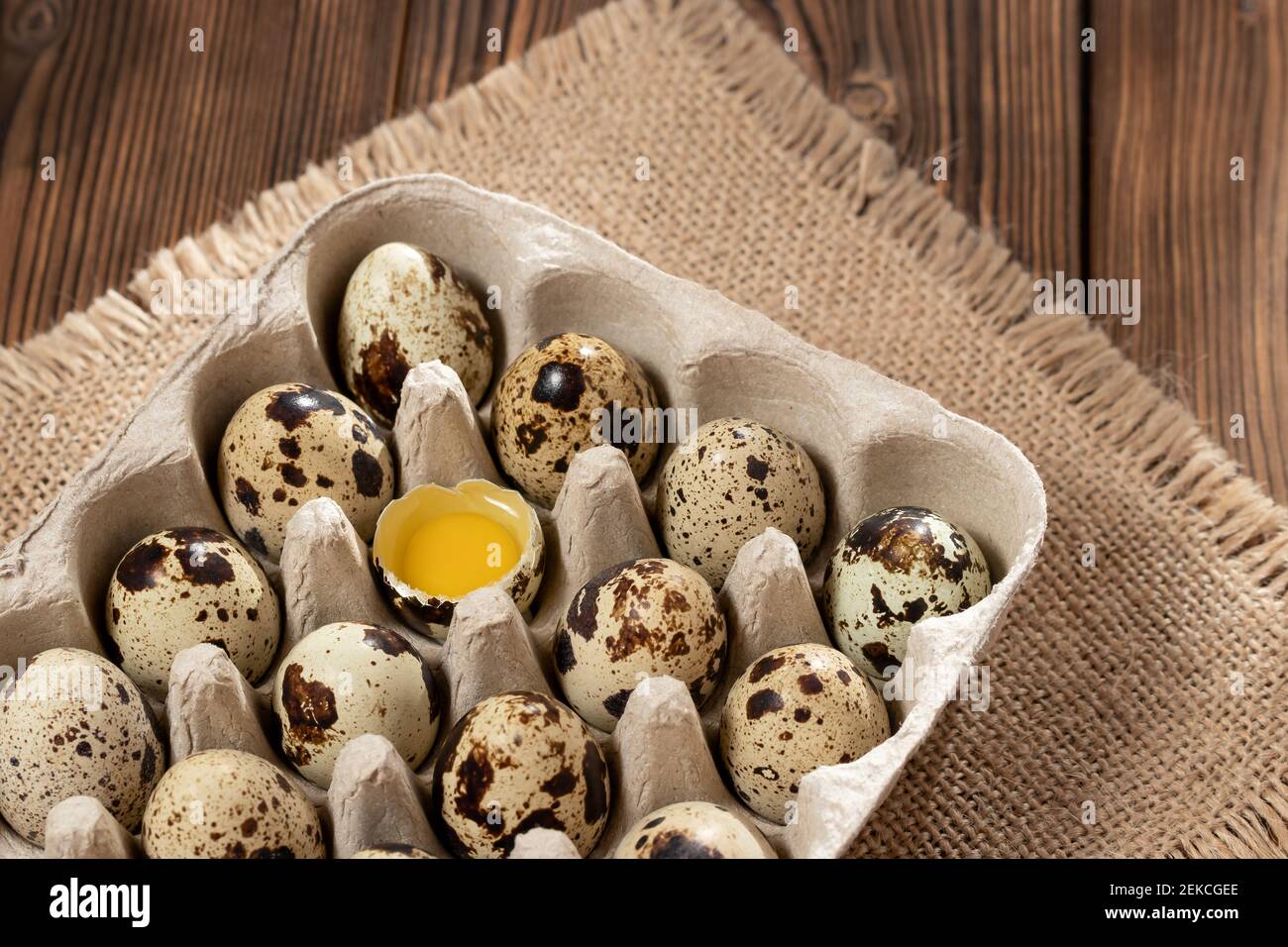 Codorniz huevos en cartón sobre una mesa de madera. Foto de stock