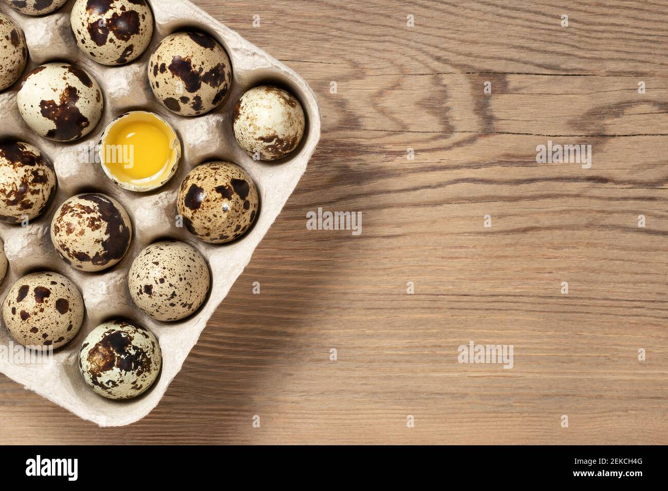 Codorar los huevos en el embalaje de cartón sobre una mesa de madera de primer plano, espacio de copia, flatlay. Foto de stock