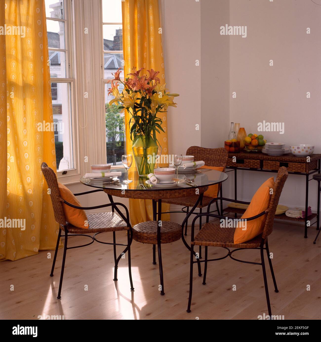 Comedor con cortinas amarillas, mesa de metal y sillas en ventana de la  bahía Fotografía de stock - Alamy