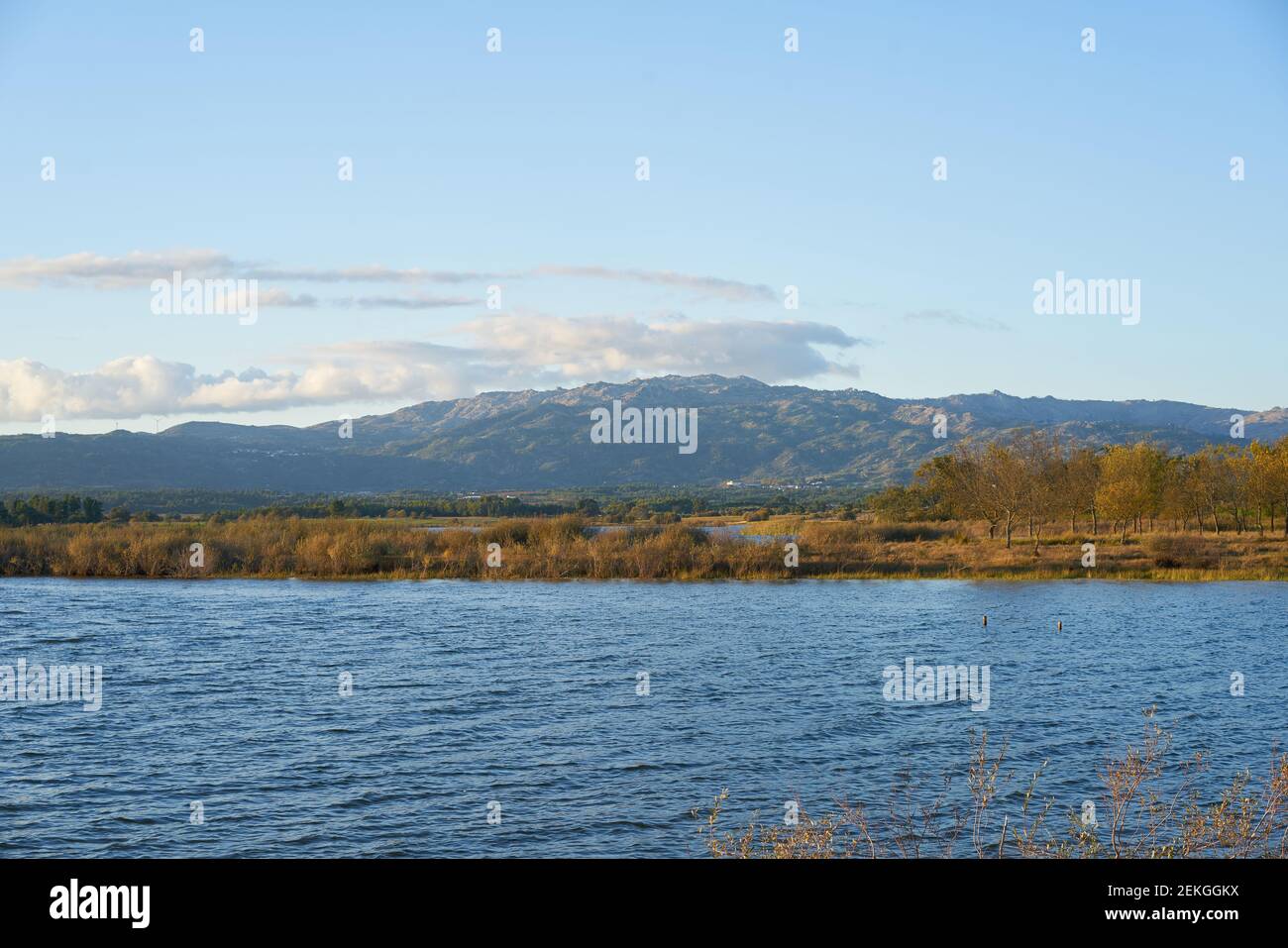 Paisaje de la presa del lago con reflejo de las montañas y los árboles de Gardunha En un día nublado en la presa de Santa Agueda Marateca en Portugal Foto de stock