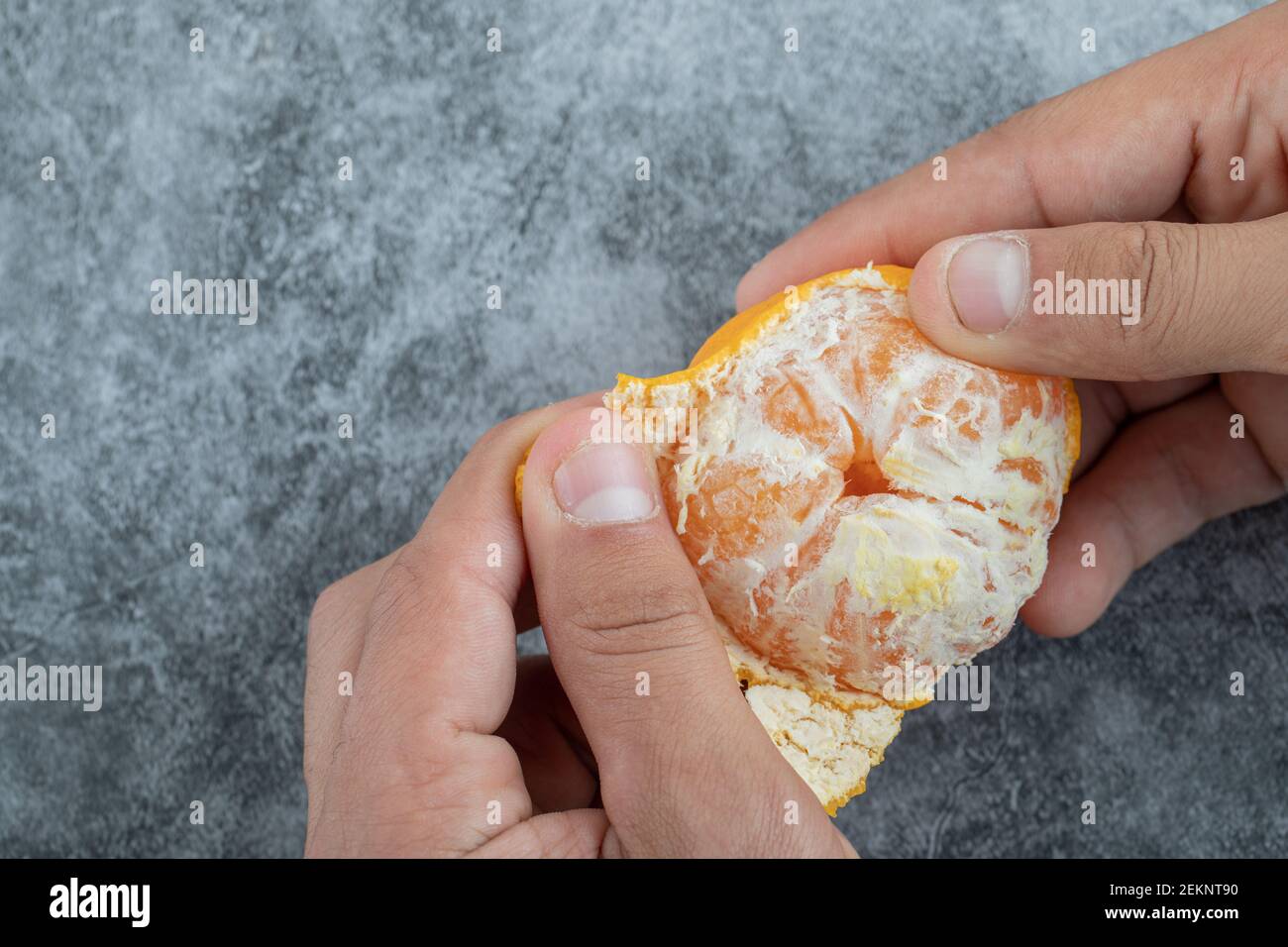 Pelando una mandarina, quitando concha a una mandarina. Stock