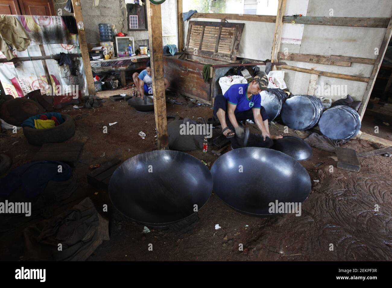 Un artesano trabaja en la fabricación de una cacerola de wok hecha de chapa  de acero en la industria del hogar de wok, "Kampung Berisik", Bogor City,  Java Occidental, Indonesia, 5 de