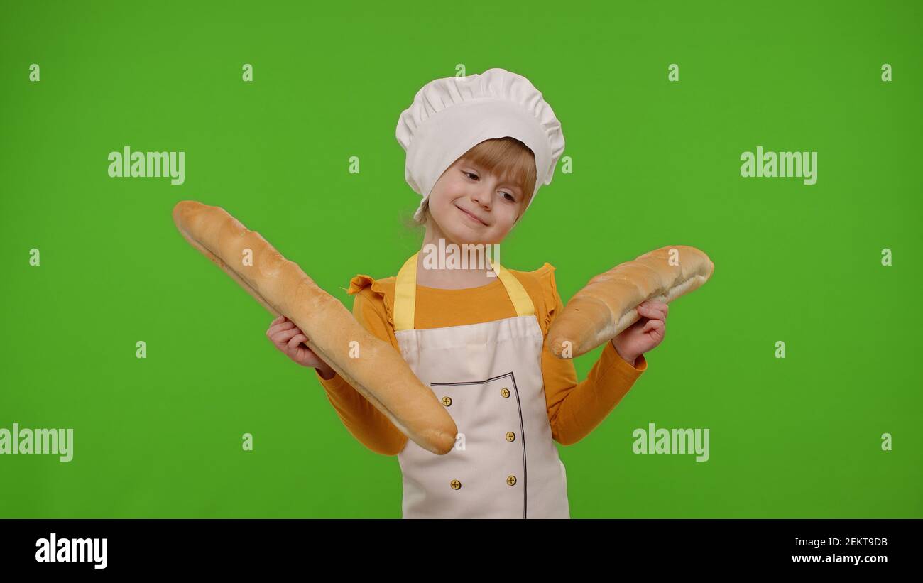 Divertida Nina Caucasica Vestida Como Cocinero Panadero En Delantal Y Sombrero Olfateando Dos Baguettes Enganando Alrededor Haciendo Caras Aisladas En El Fondo Clave De Chroma Escuela De Cocina Educacion Infantil Fotografia De