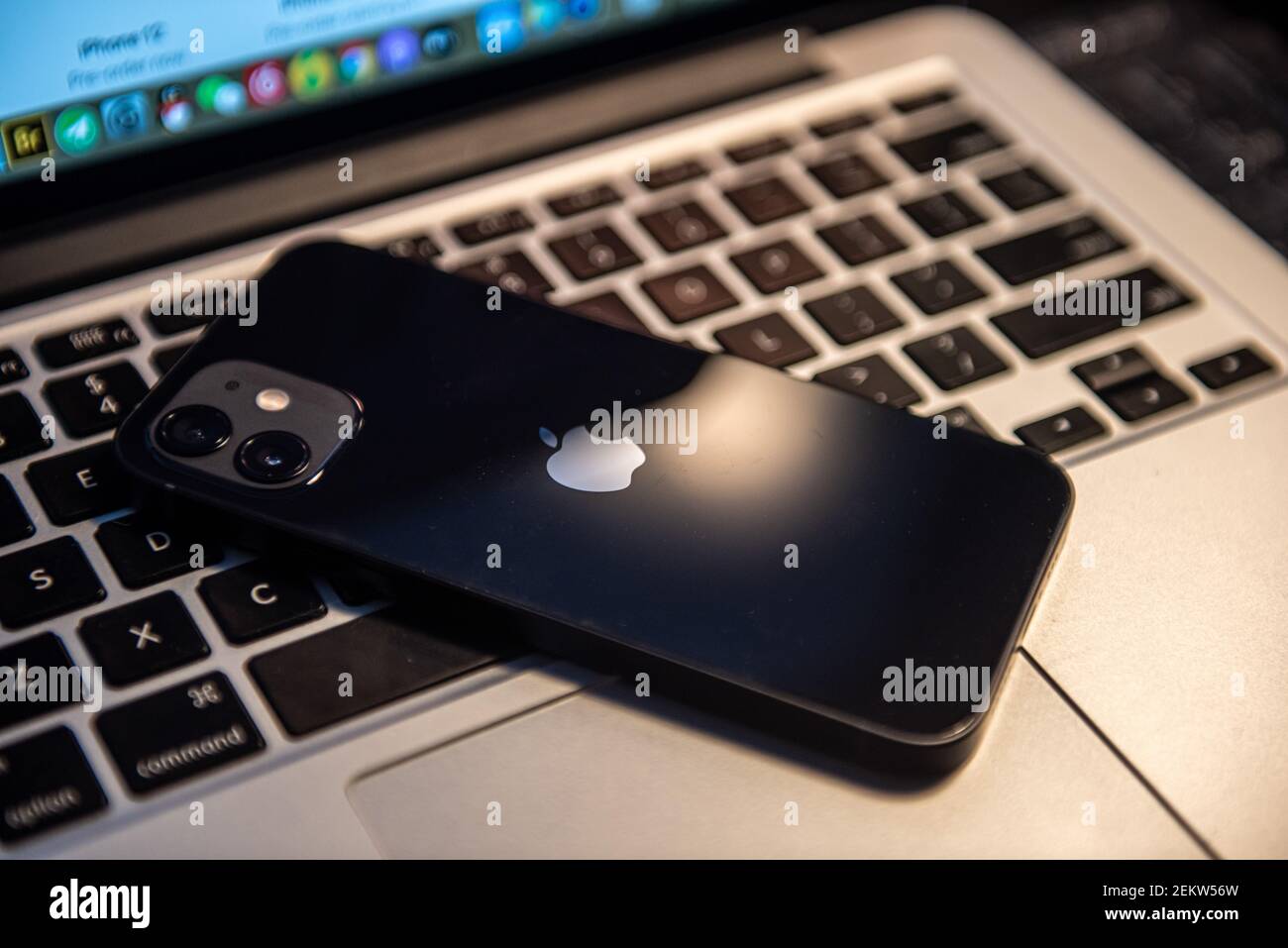 En esta ilustración de la foto se coloca un smartphone iPhone 12 en un  teclado de un portátil MacBook Pro. Se puede ver el diseño de cámara dual  en la parte trasera.