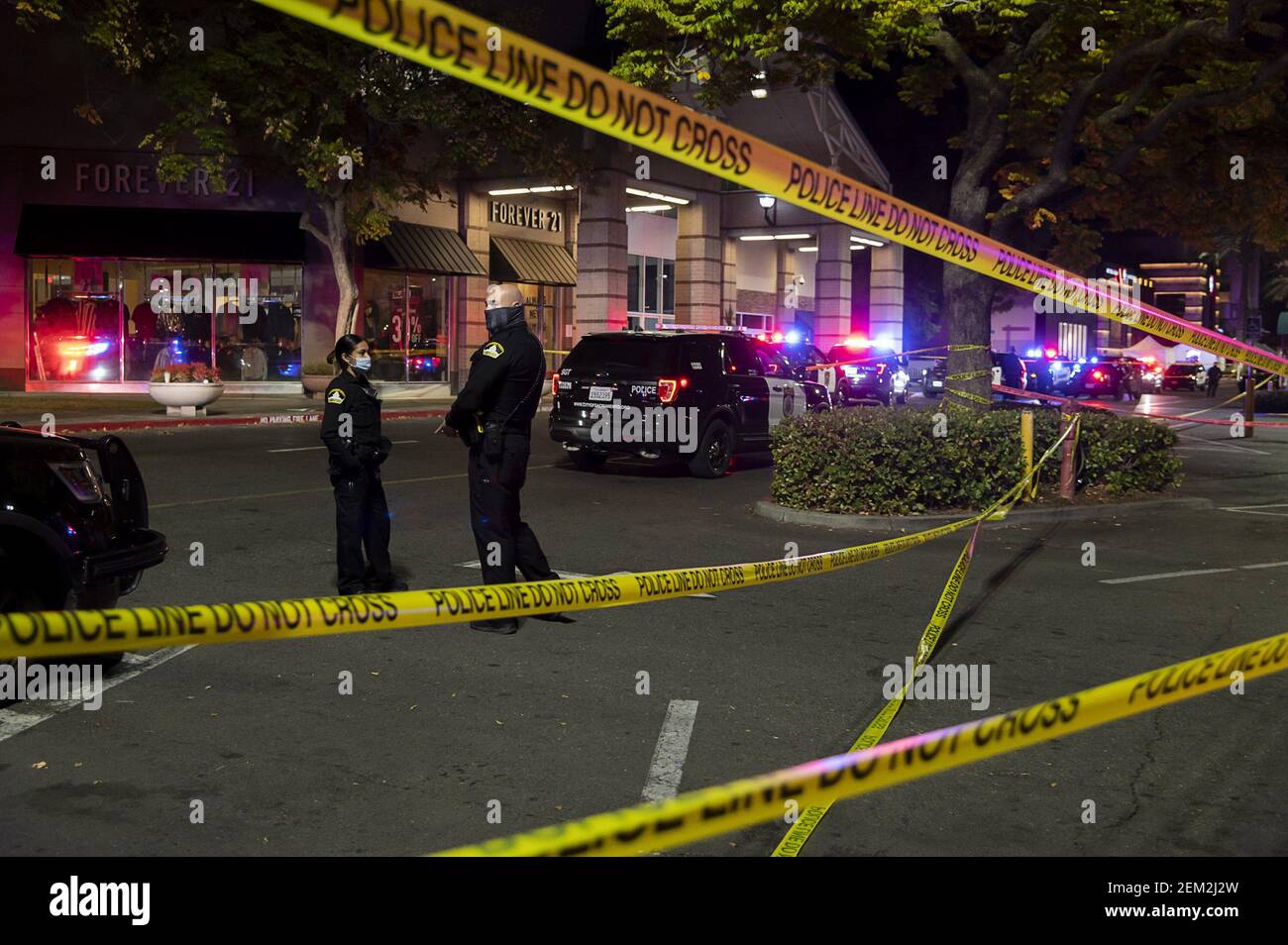 Los oficiales del Departamento de Policía de Sacramento están vigilados detrás de la cinta de escena del crimen en el centro comercial Arden Fair en Sacramento, California, después de un tiroteo mató a dos personas el Viernes Negro, 27 de noviembre de 2020. (Foto de Paul Kitagaki Jr./Sacramento Bee/TNS/Sipa USA) Foto de stock