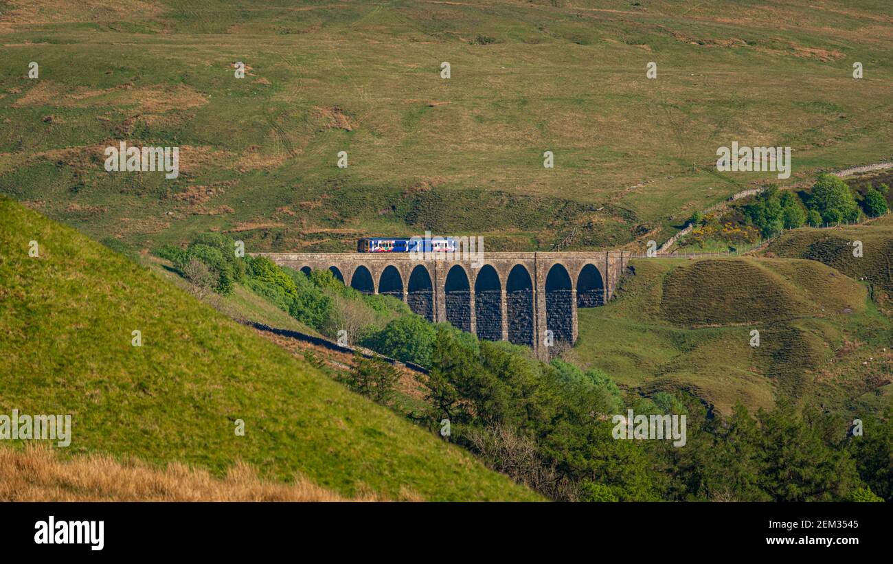 Cerca de Cowgill, Cumbria, Inglaterra, Reino Unido - 16 de mayo de 2019: Un tren que pasa por el viaducto Arten Gill en la línea de ferrocarril Settle-Carlisle Foto de stock