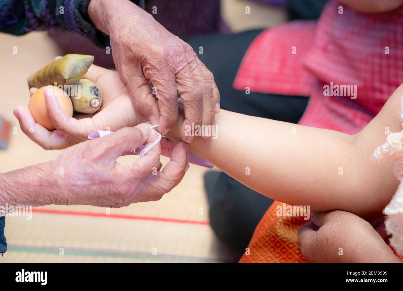 La ceremonia de atar la muñeca de la gente con el hilo santo para la consola de la gente Kwan. Cultura tailandesa. Creencias y cultura local del noreste de Tailandia. Foto de stock
