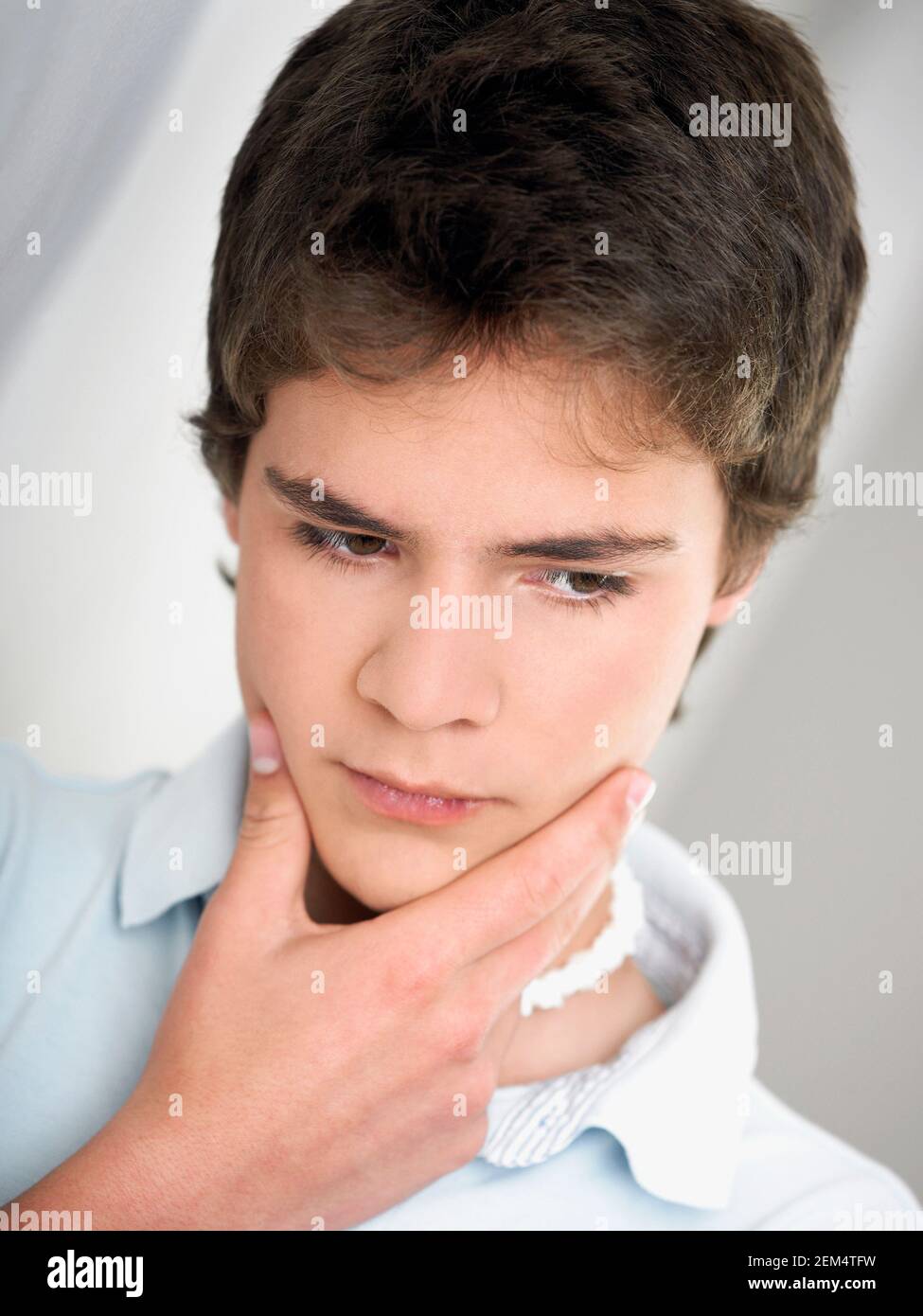 Primer plano de un adolescente con su mano en la suya mentón Foto de stock