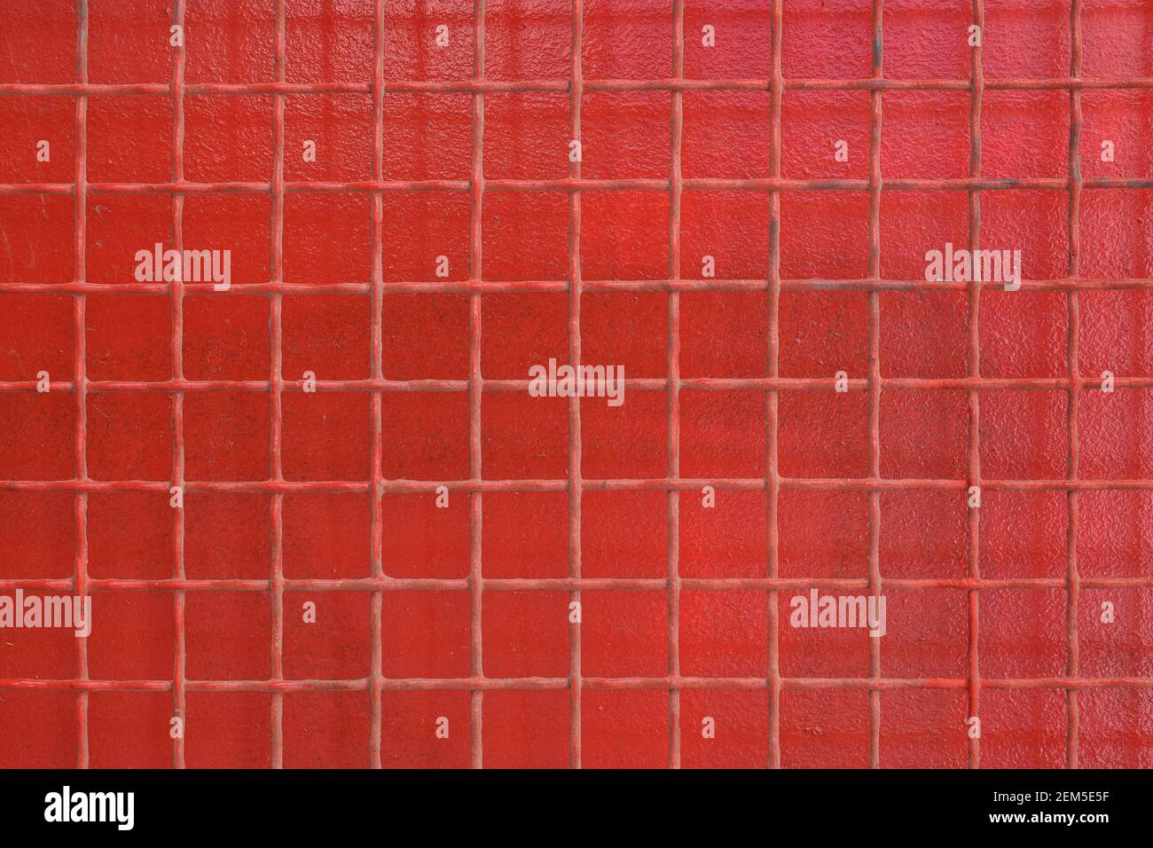 Rejilla de alambre de hierro oxidado cuadrados patrón sobre fondo de metal pintado de color rojo. Foto de stock